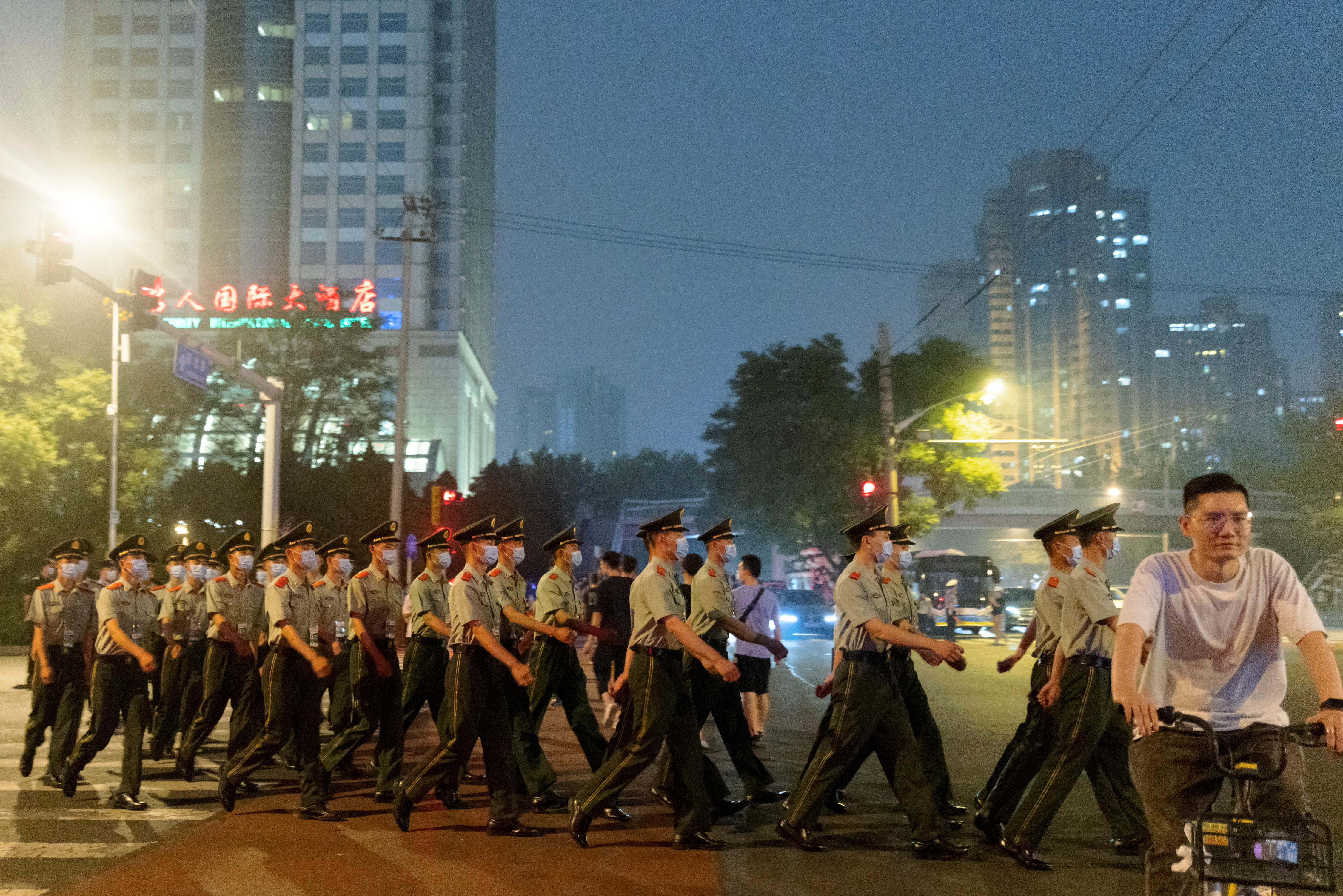 Officers of the People's Armed Police move into position as crowd control before a rehearsal of a fireworks display near the National Stadium ahead of the 100th founding anniversary of the Communist Party of China in Beijing