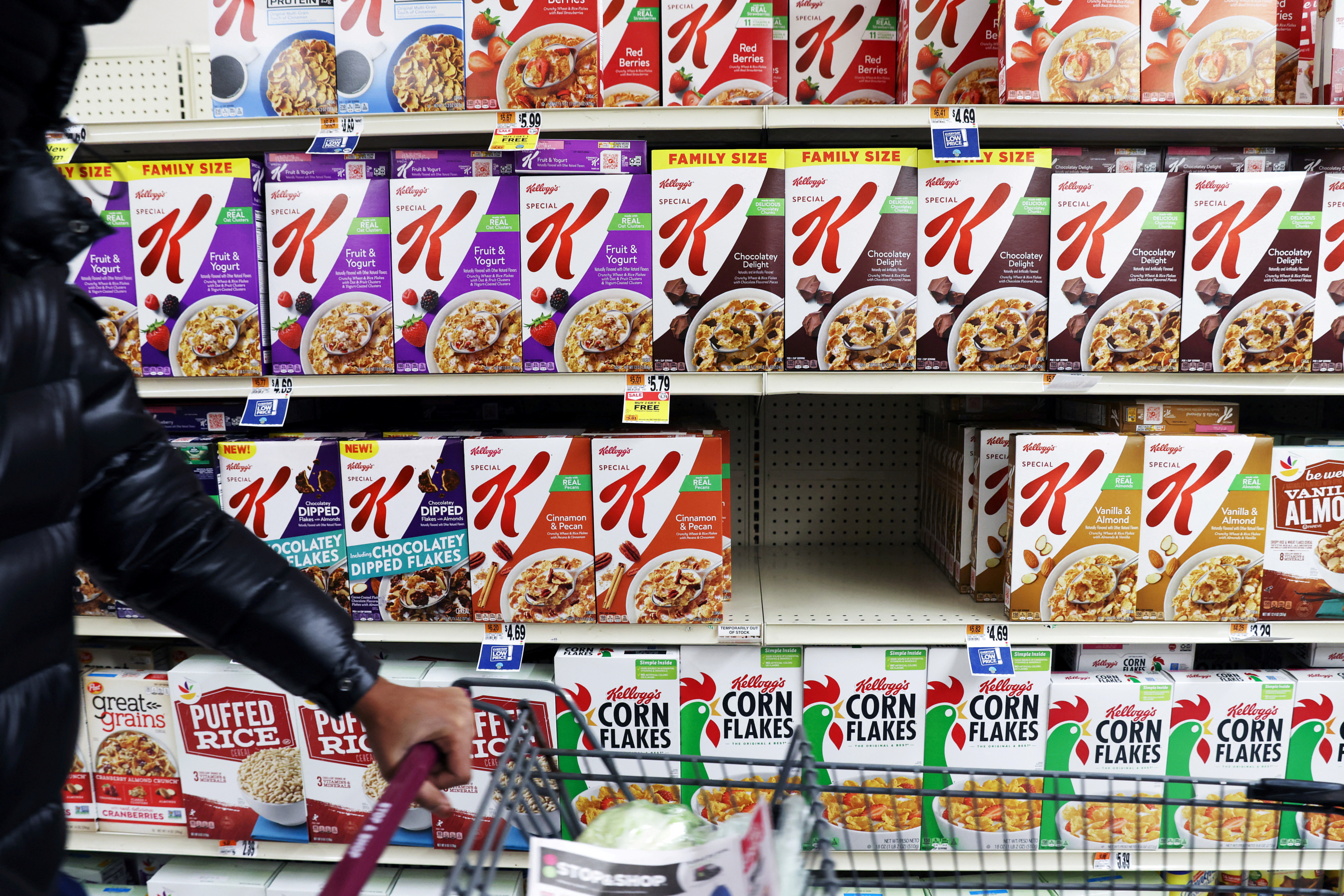 A person walks by a display of Kellogg's cereals, owned by Kellogg Company, in a store in Queens, New York City