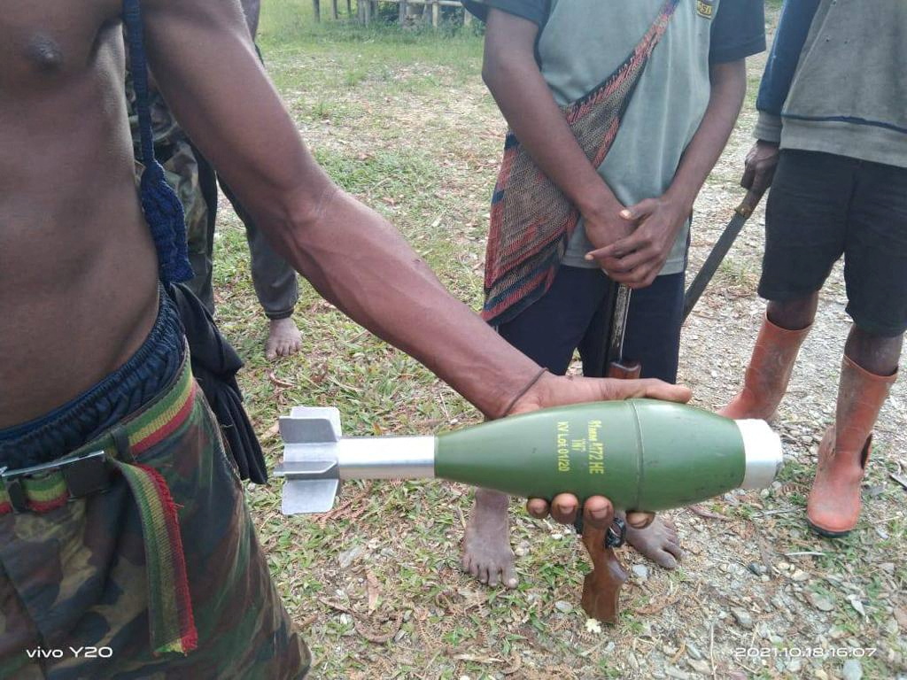 Local resident holds an unexploded mortar following aerial attacks in Kiwirok, Pegunungan Bintang regency