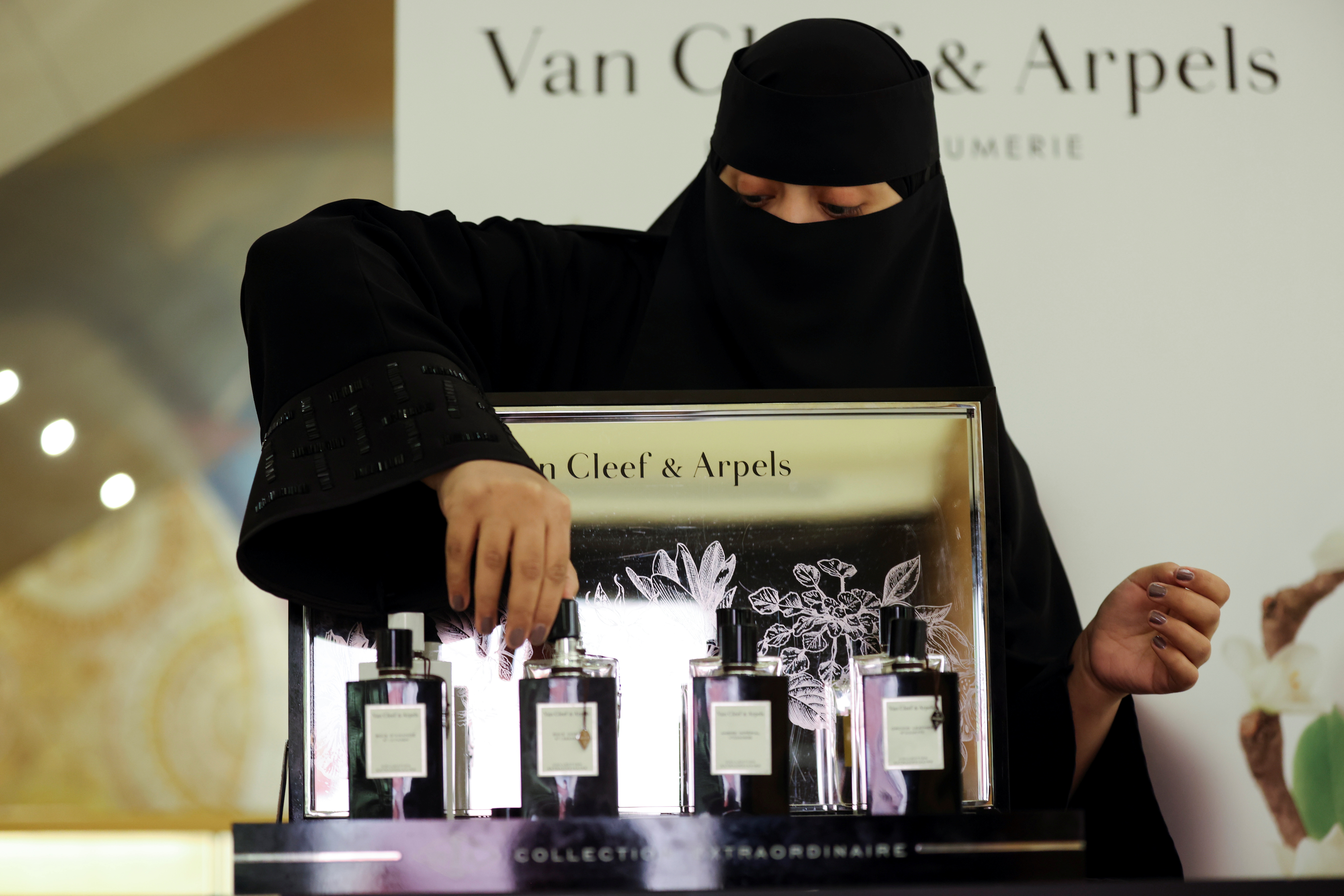Saudi woman arranges the perfumes in a cosmetic shop at Centria Mall in Riyadh