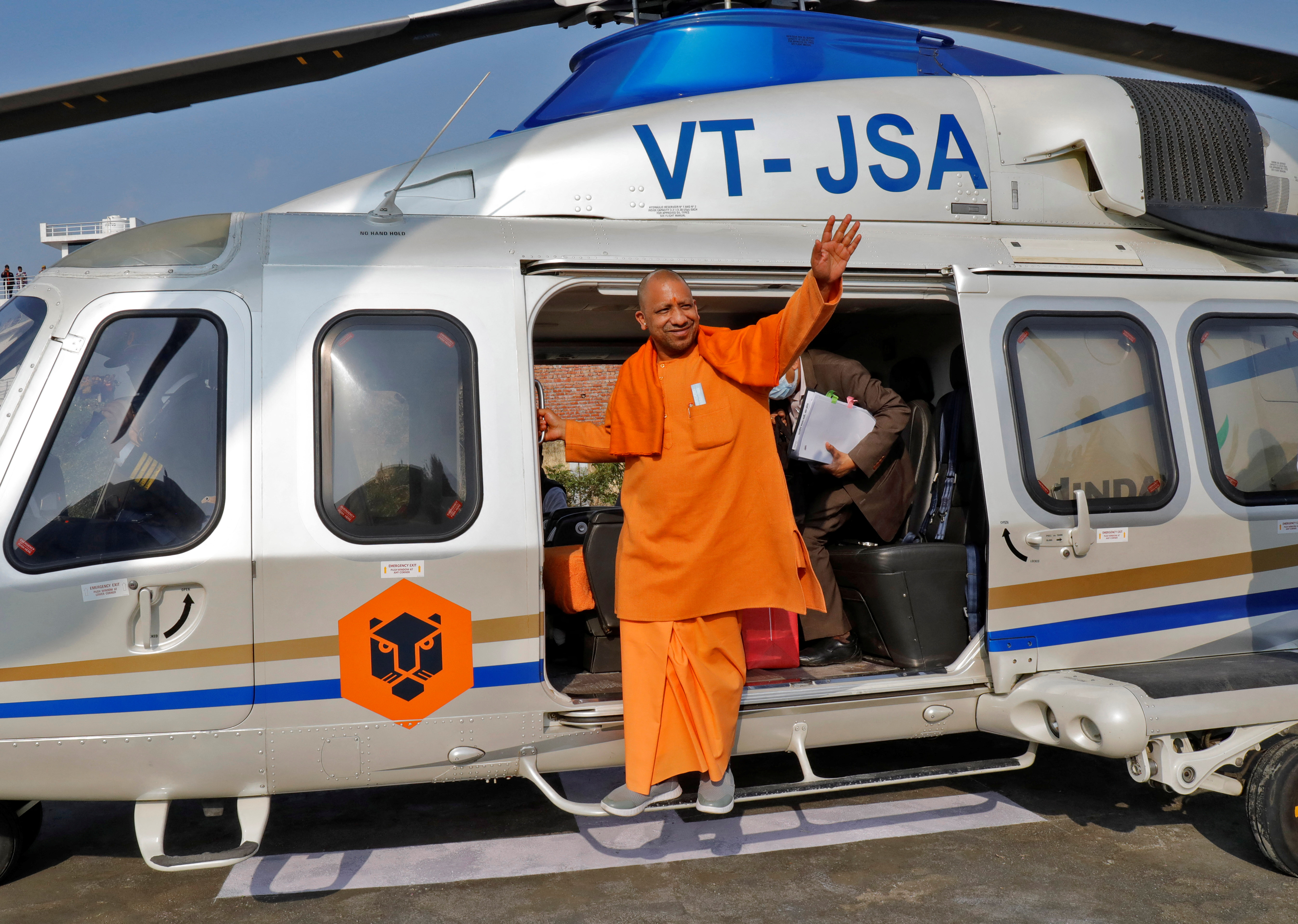Yogi Adityanath waves as he arrives to to attend an election campaign rally in Sambhal