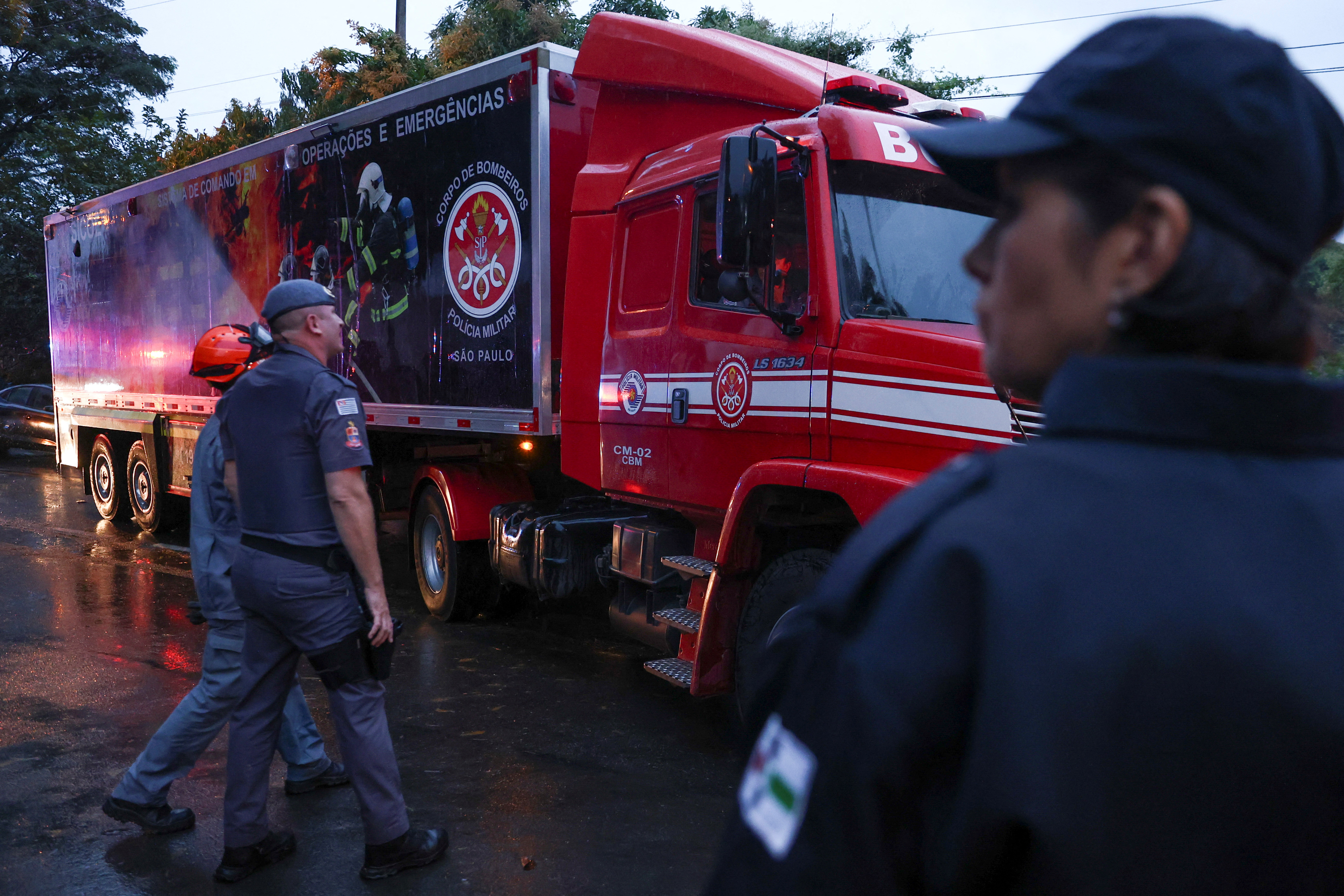 Authorities arrive at the site where a turboprop plane crashed near Sao Paulo