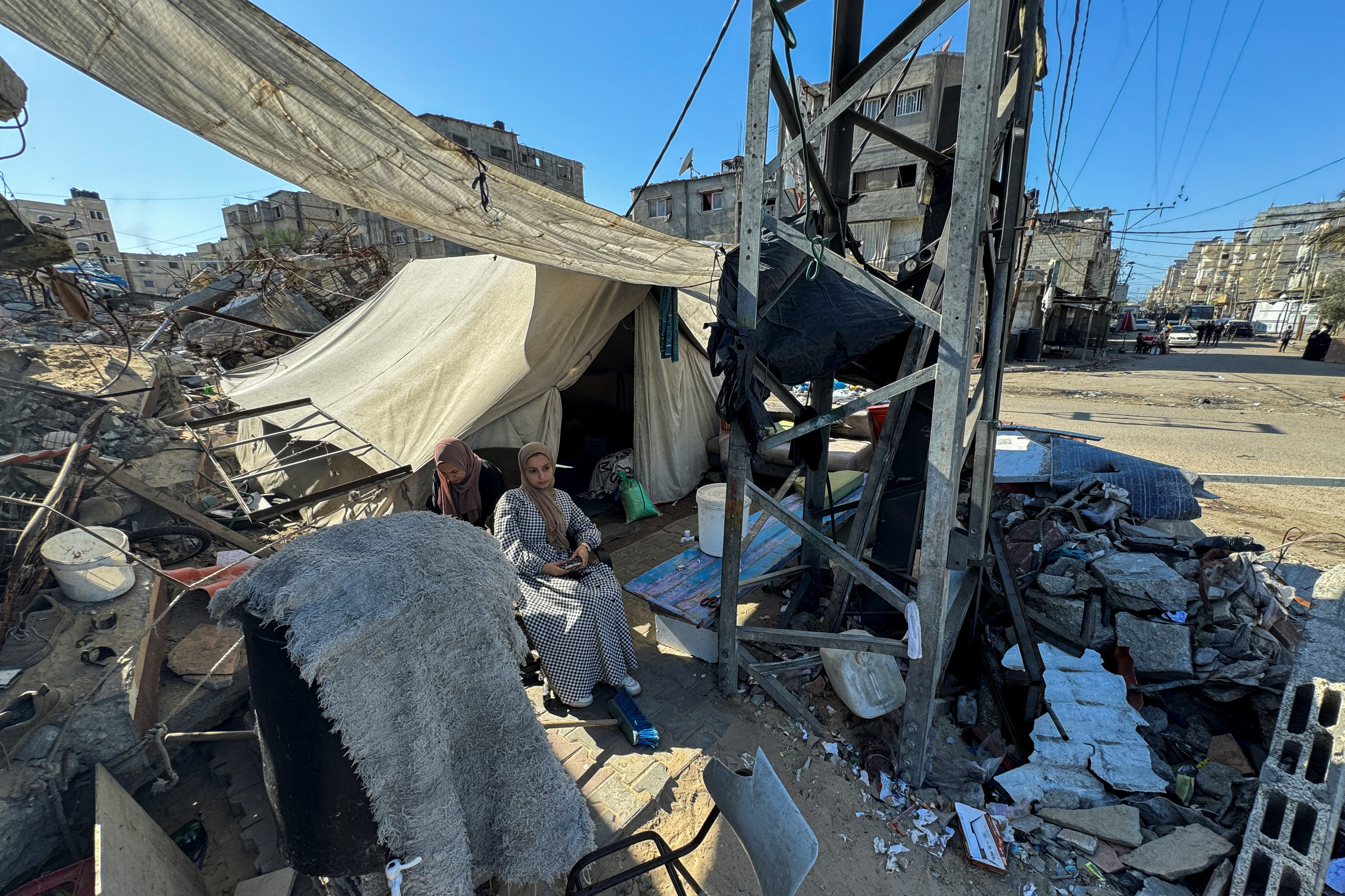 Displaced Palestinians, who fled their house due to Israel's military offensive, sit outside their tent, in Rafah, in the southern Gaza Strip
