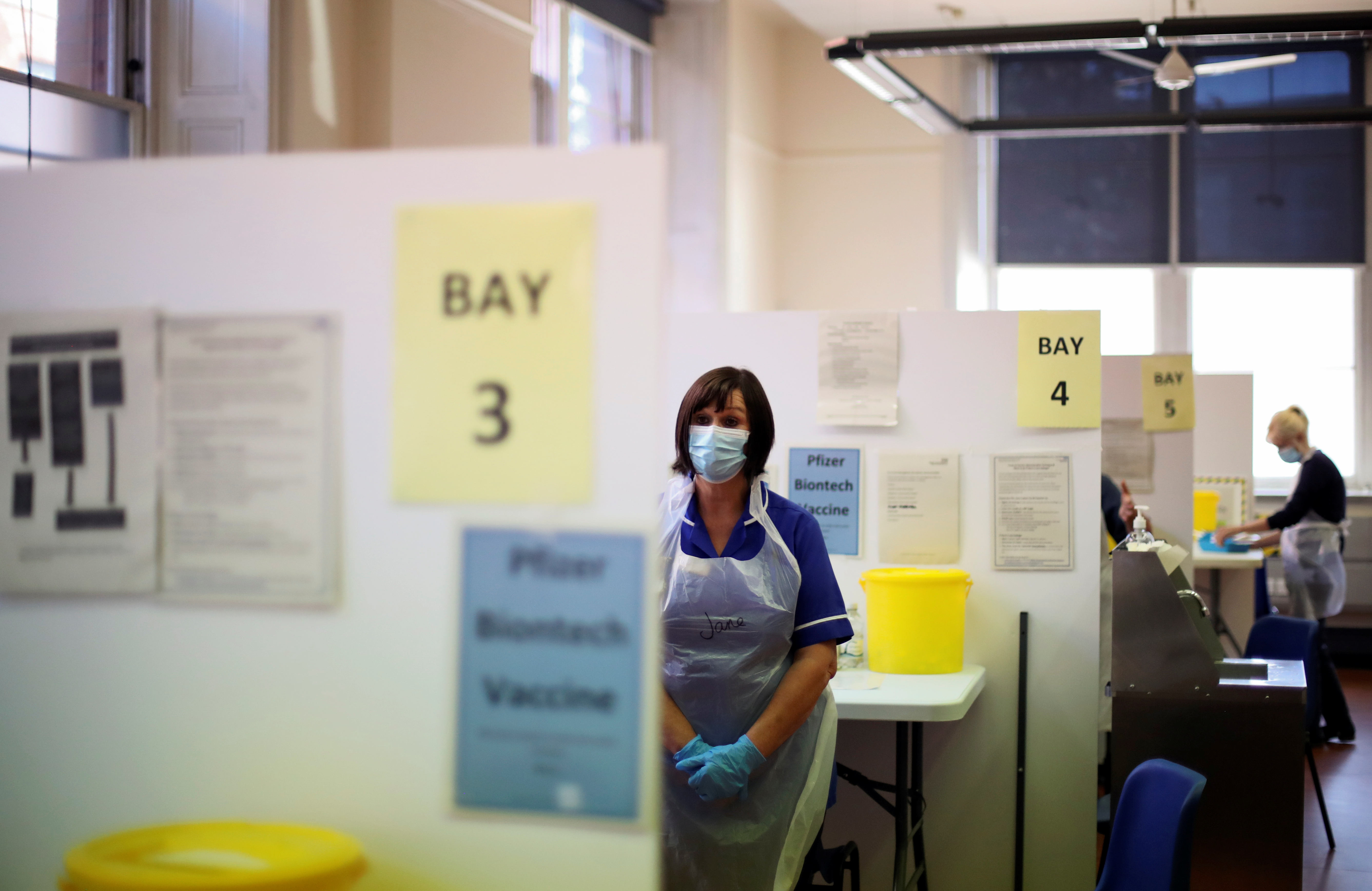 A health worker looks on at a booth as healthcare staff receive the COVID-19 booster vaccine, amid the coronavirus disease (COVID-19) pandemic, at Midland House in Derby, Britain, September 20, 2021. REUTERS/Carl Recine