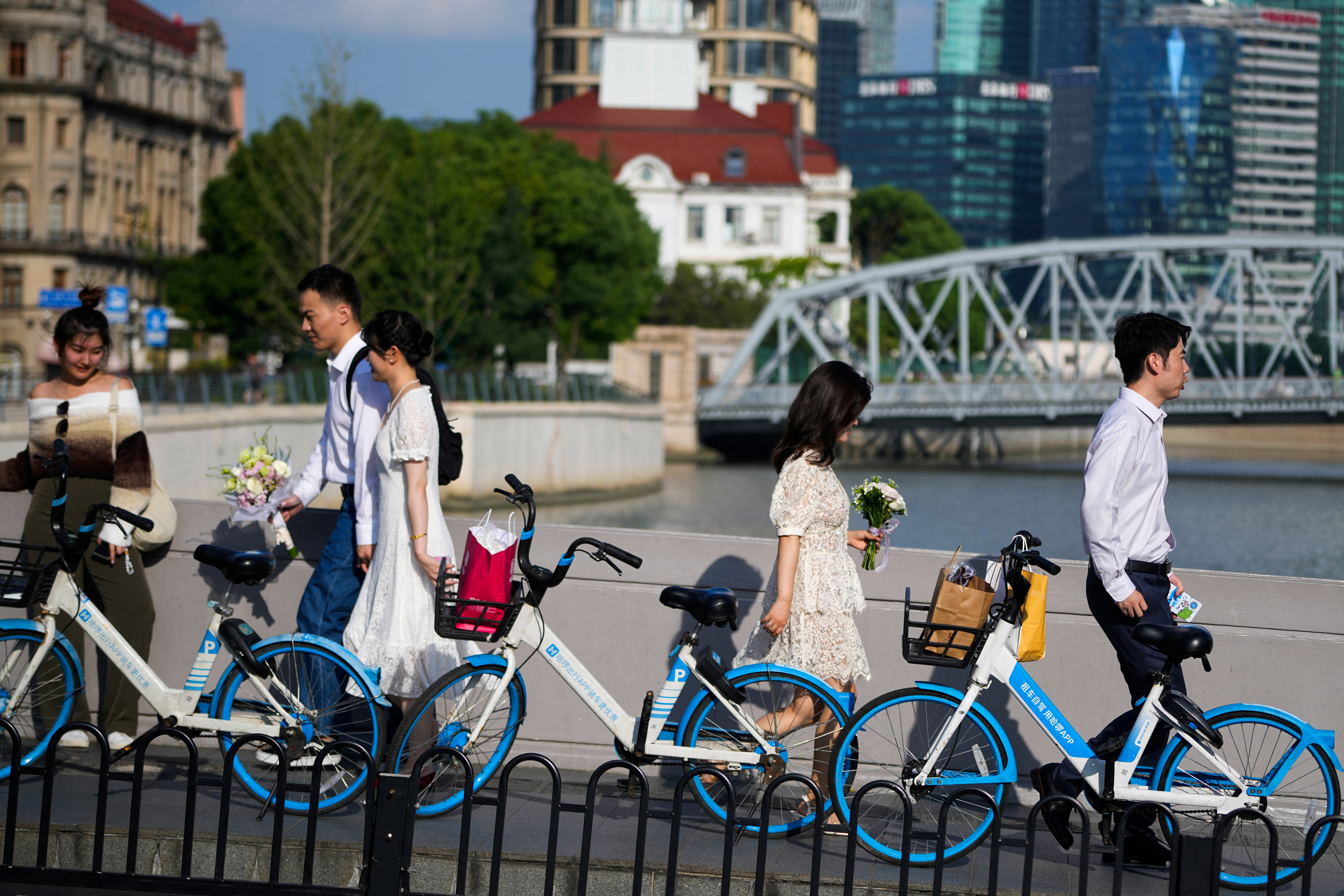 Couples prepare to get their photo taken during a wedding photography shoot on a street, in Shanghai