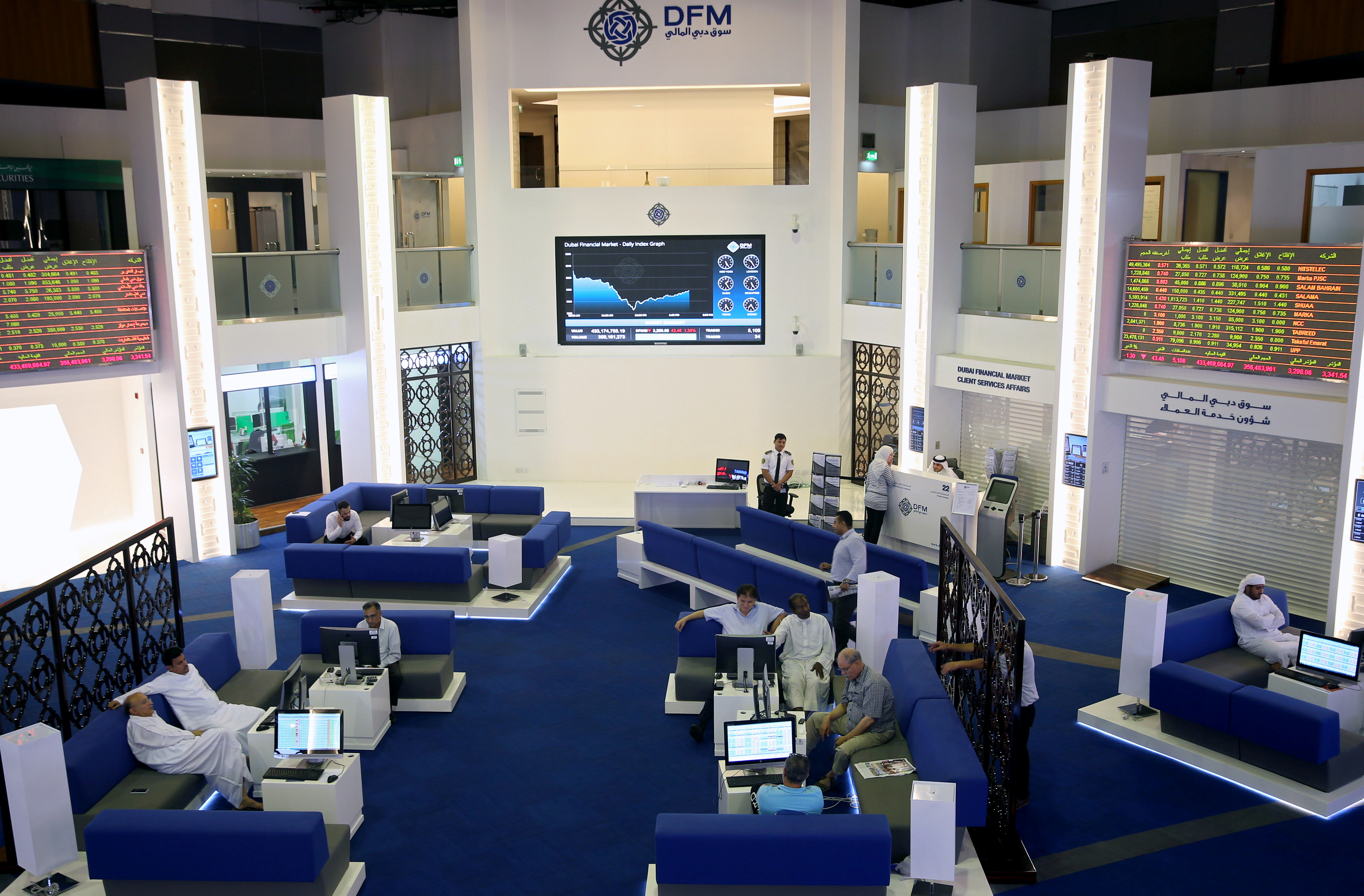 Traders monitor stock information at Dubai Financial Market, in Dubai