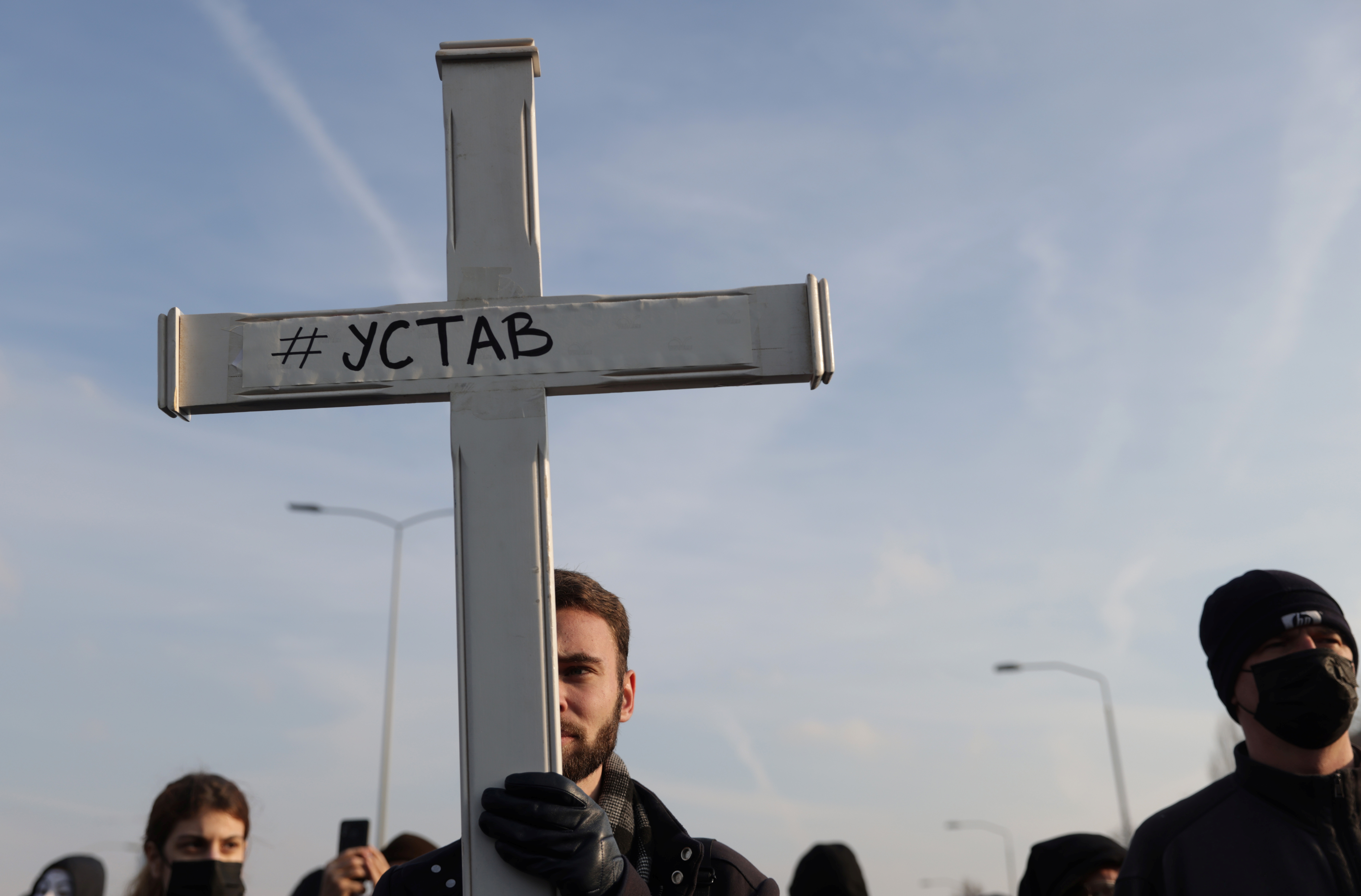 An anti-government protester holds a cross during a protest in Belgrade