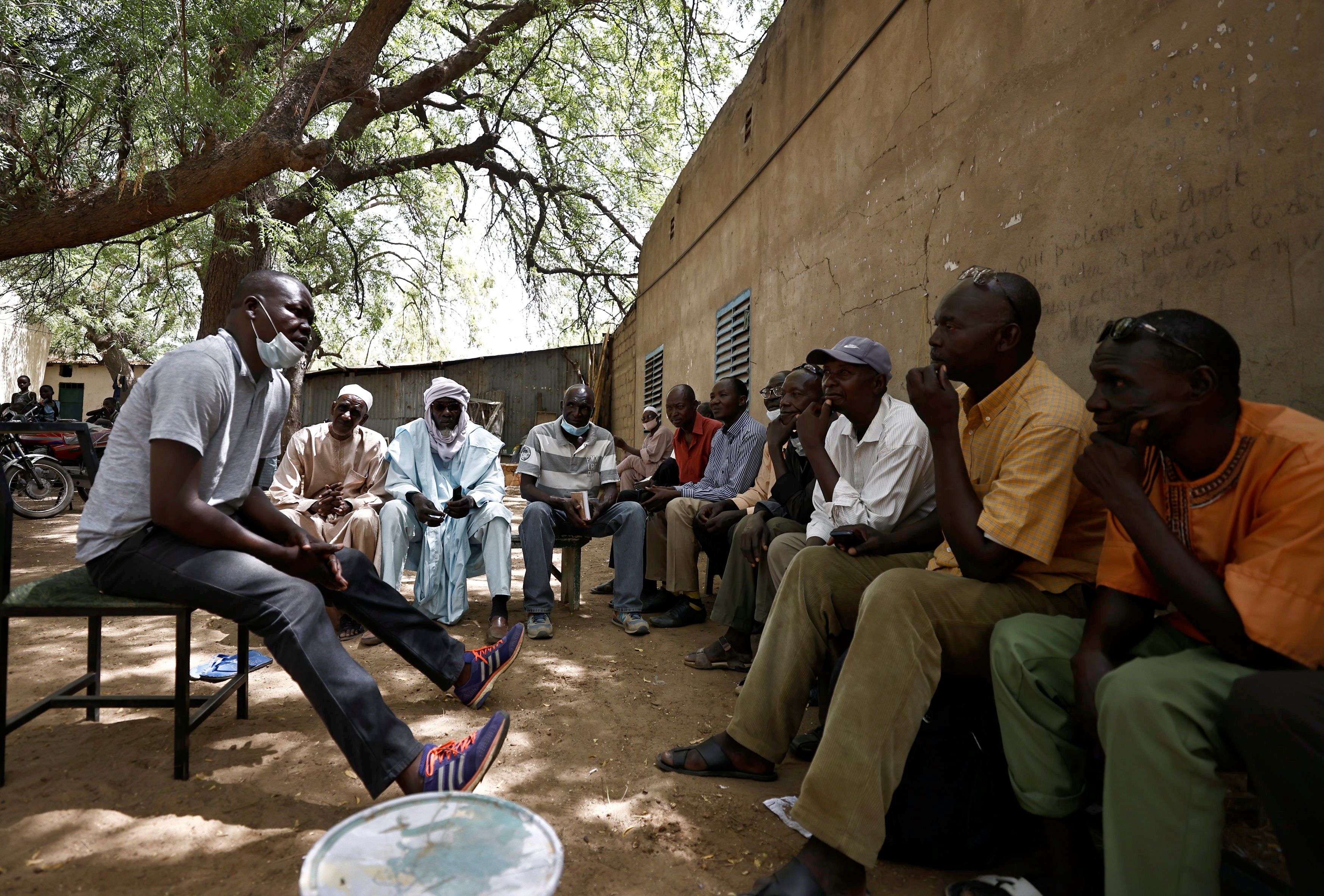 Men sit in shade outside CLTT office in N'djamena