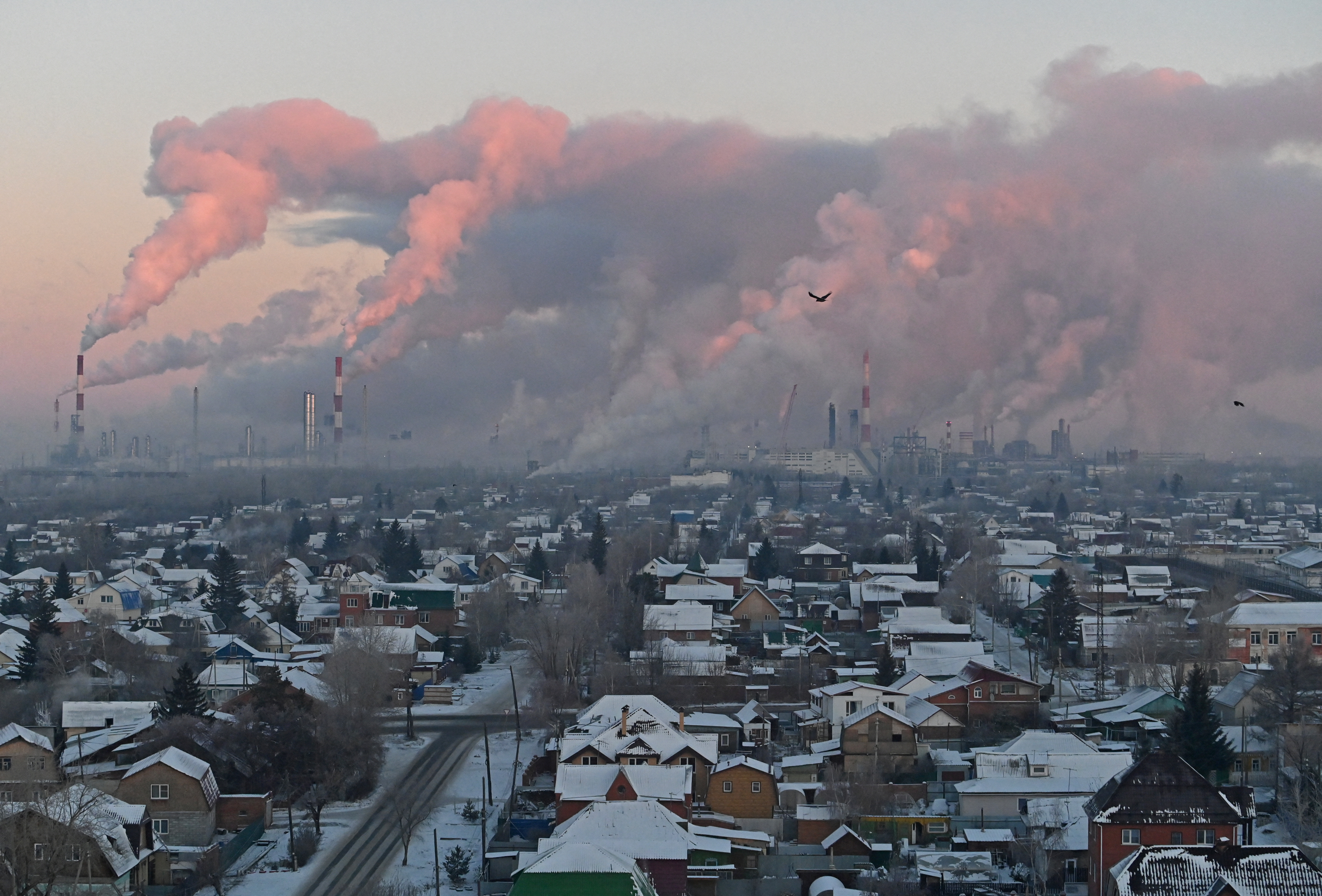Steam rises from chimneys of the Gazprom Neft's oil refinery in Omsk