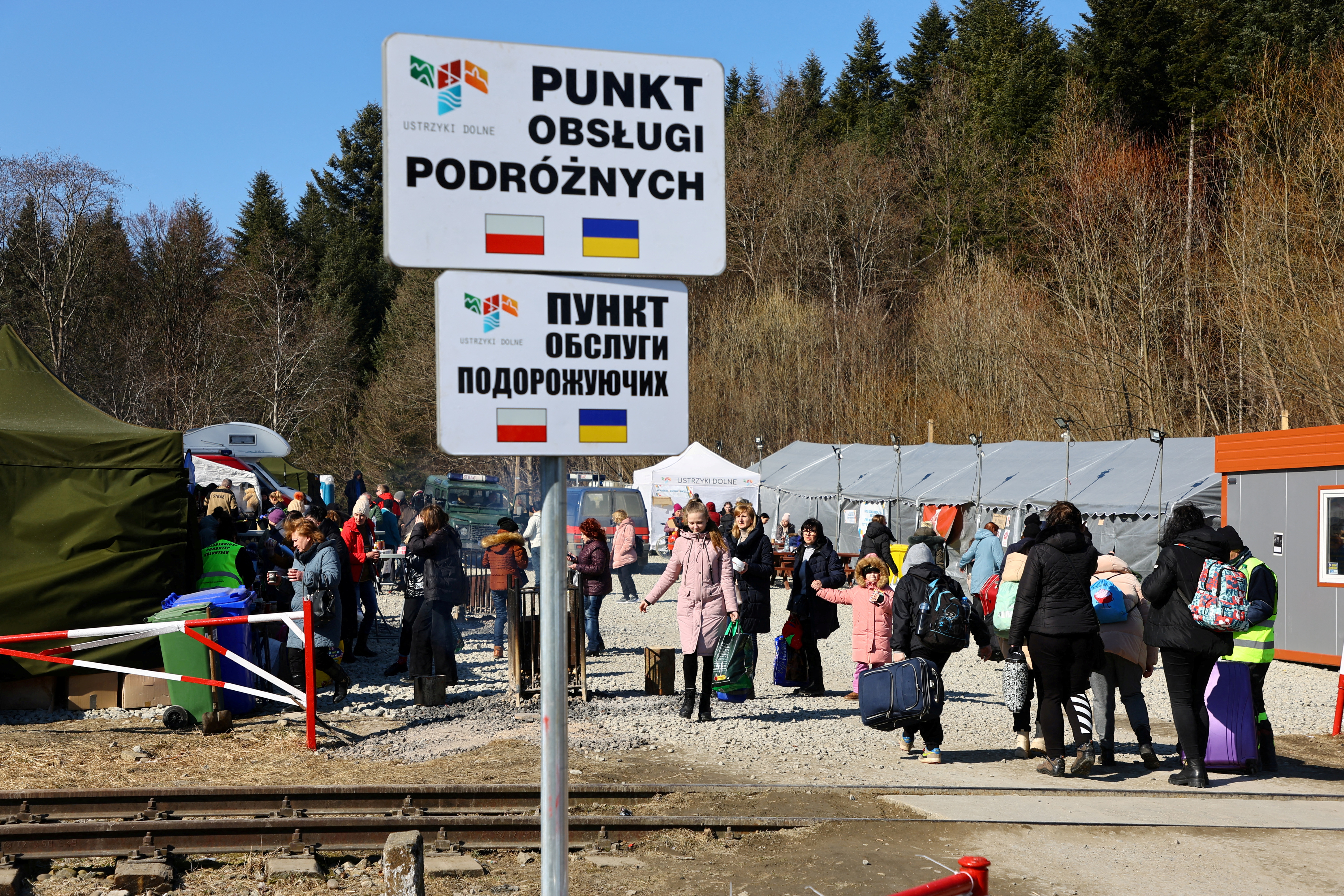People fleeing Russia's invasion of Ukraine arrive at a border checkpoint in Kroscienko