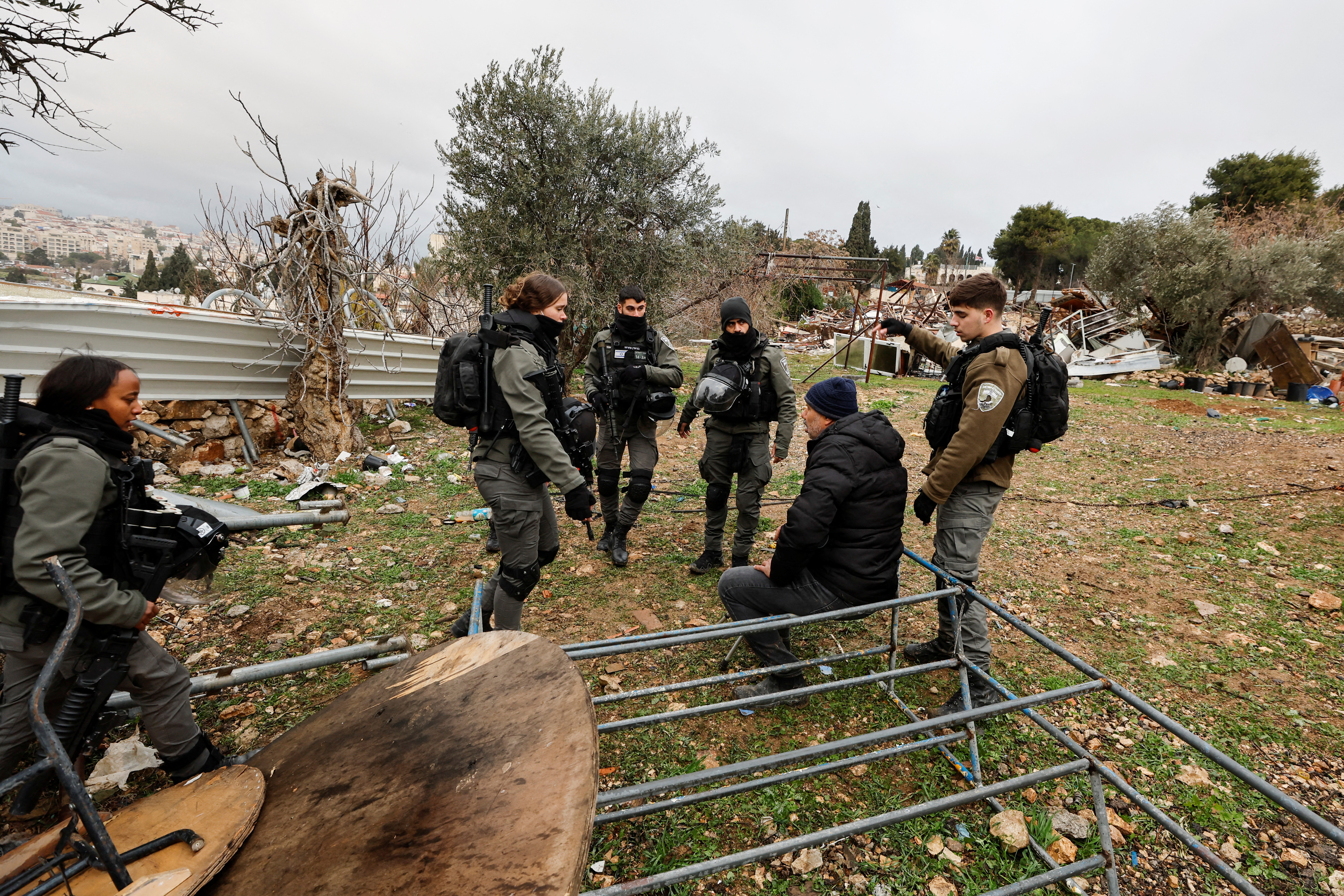Members of the Israeli border police speak with a Palestinian man at the site of a demolished house in the Sheikh Jarrah neighbourhood of East Jerusalem