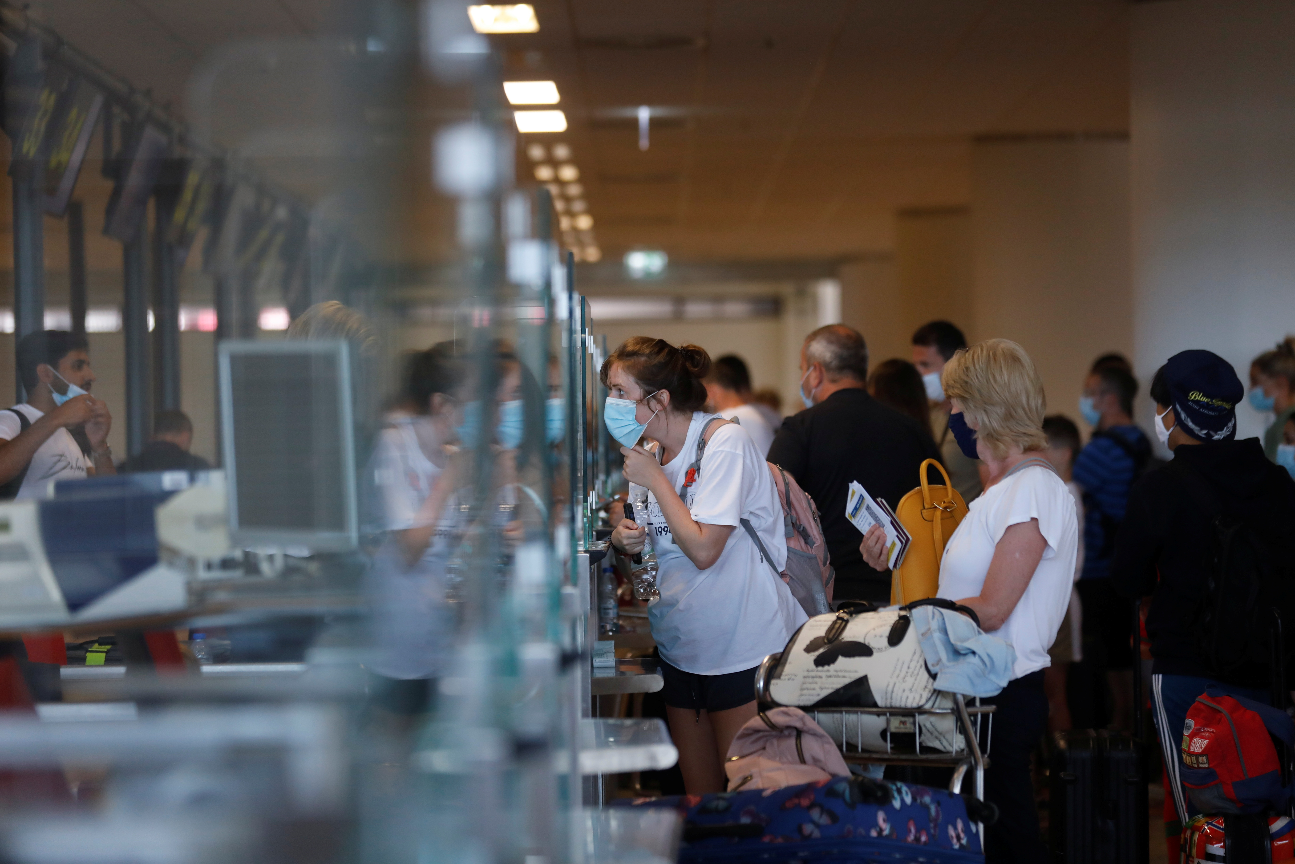 People queue at check in desks at Faro airport amid the COVID-19 pandemic, in Faro