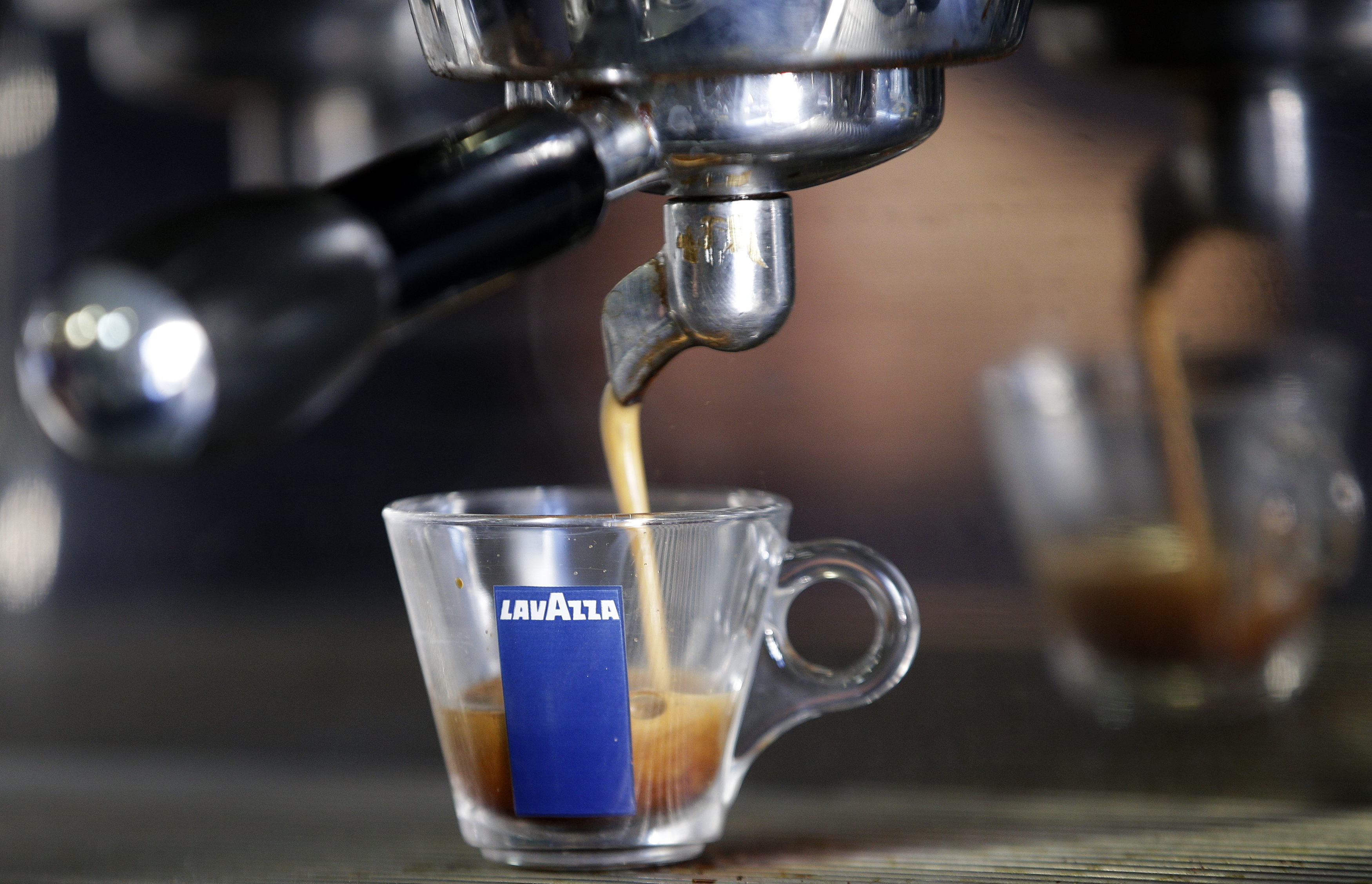 Coffee flows into a Lavazza cup at a coffee shop in Rome