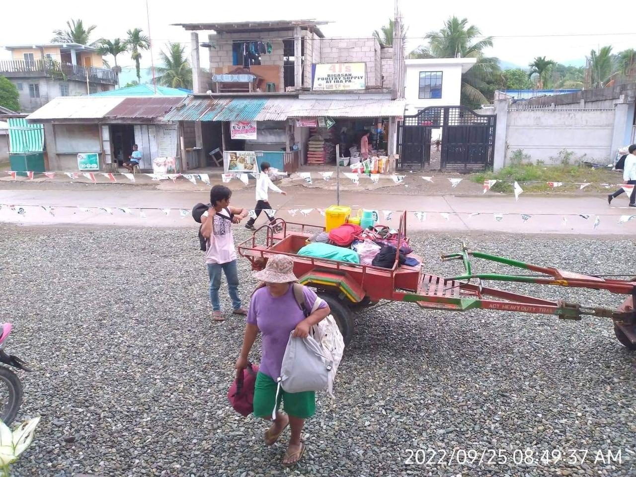 Residents carry belongings to evacuation centre in Aurora Province, Philippines