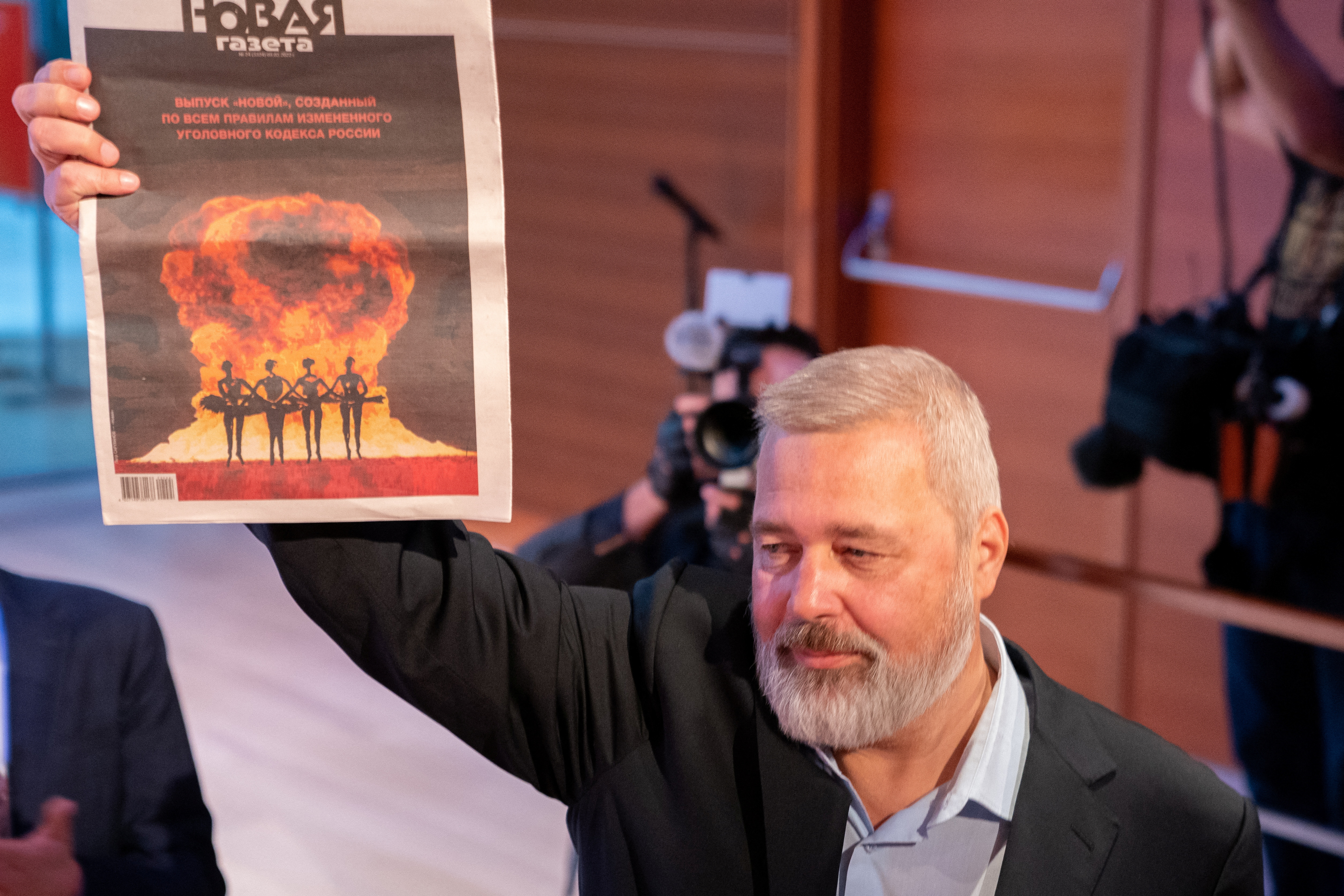 Dmitry Muratov holds a copy of his newspaper the Novaya Gazeta after his 2021 Nobel Peace Prize medal sold for 103.5  Million