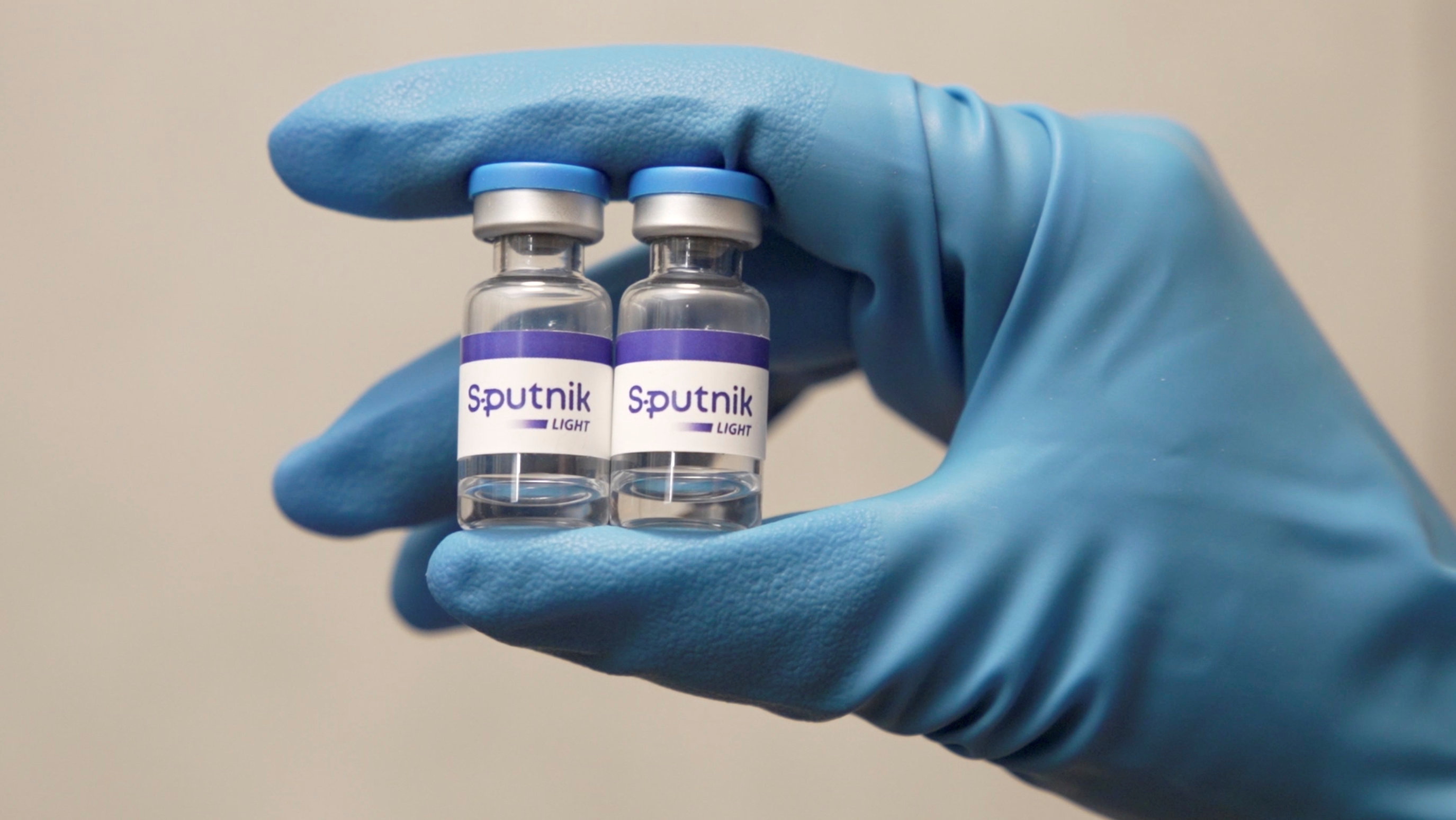 An employee demonstrates samples of Sputnik Light COVID vaccine