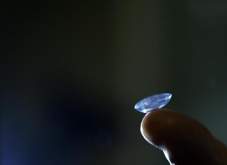 Dr. Alan Titelbaum from the Eye Associates of Somerville, holds up a contact lens at his practice in Somerville