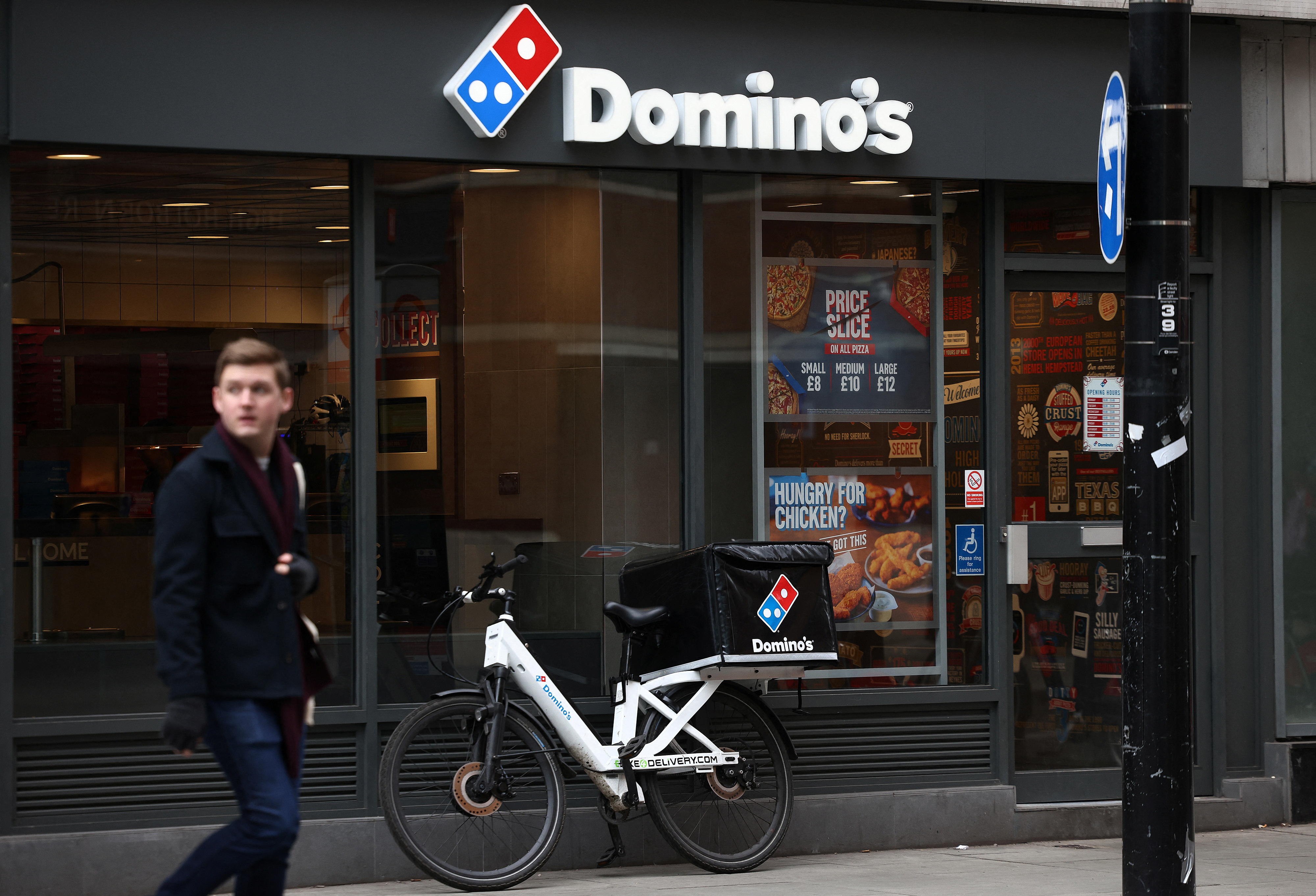 A person walks past a Domino's pizza restuarant in London