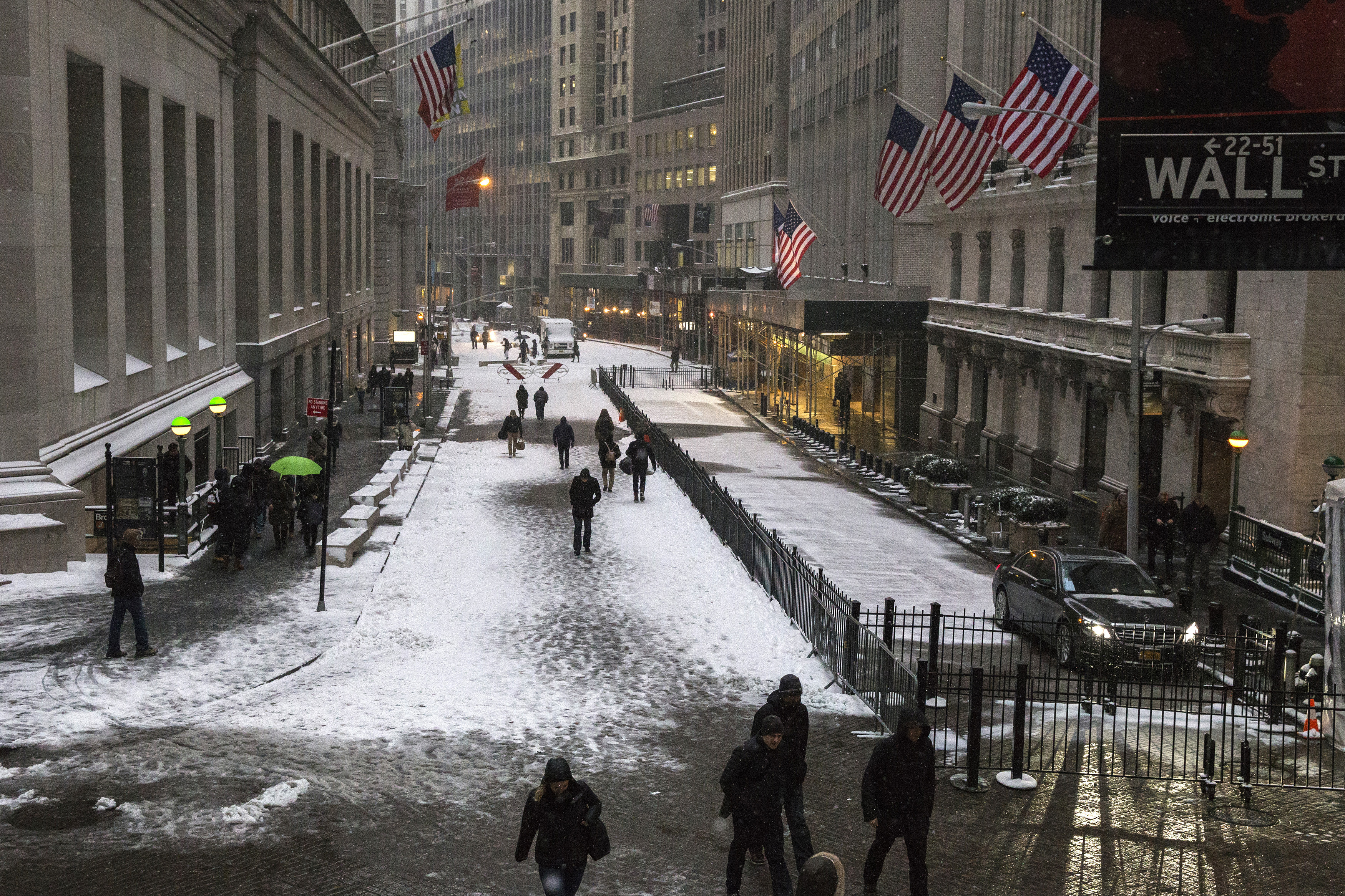 Commuters walk through the Financial District during a snow storm in Lower Manhattan