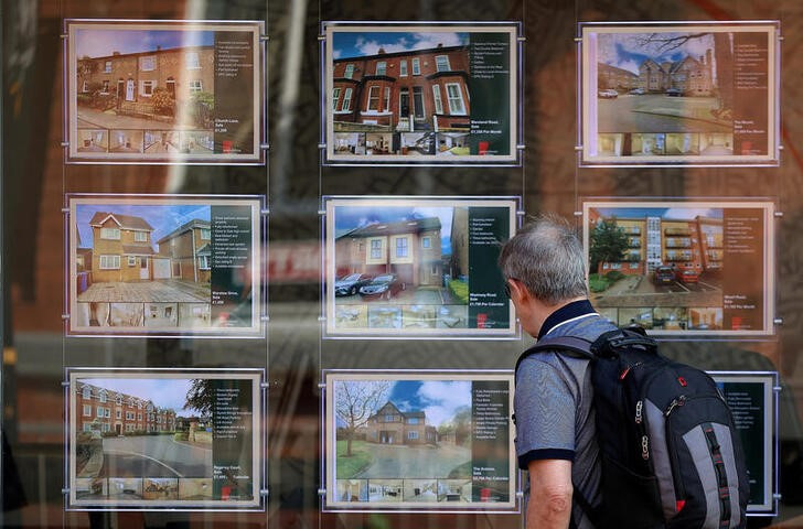 A man looks at houses for sale in the window of an estate agents in Manchester, Britain