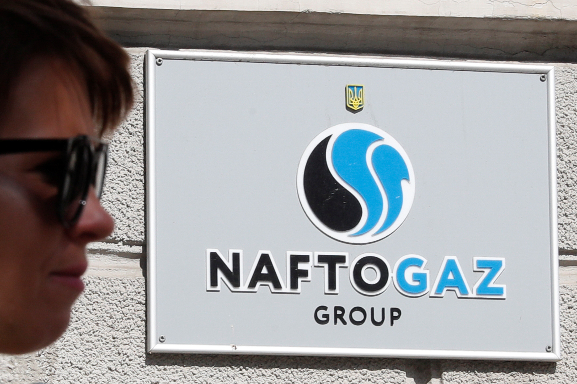 A woman walks past the headquarters of Naftogaz in Kiev