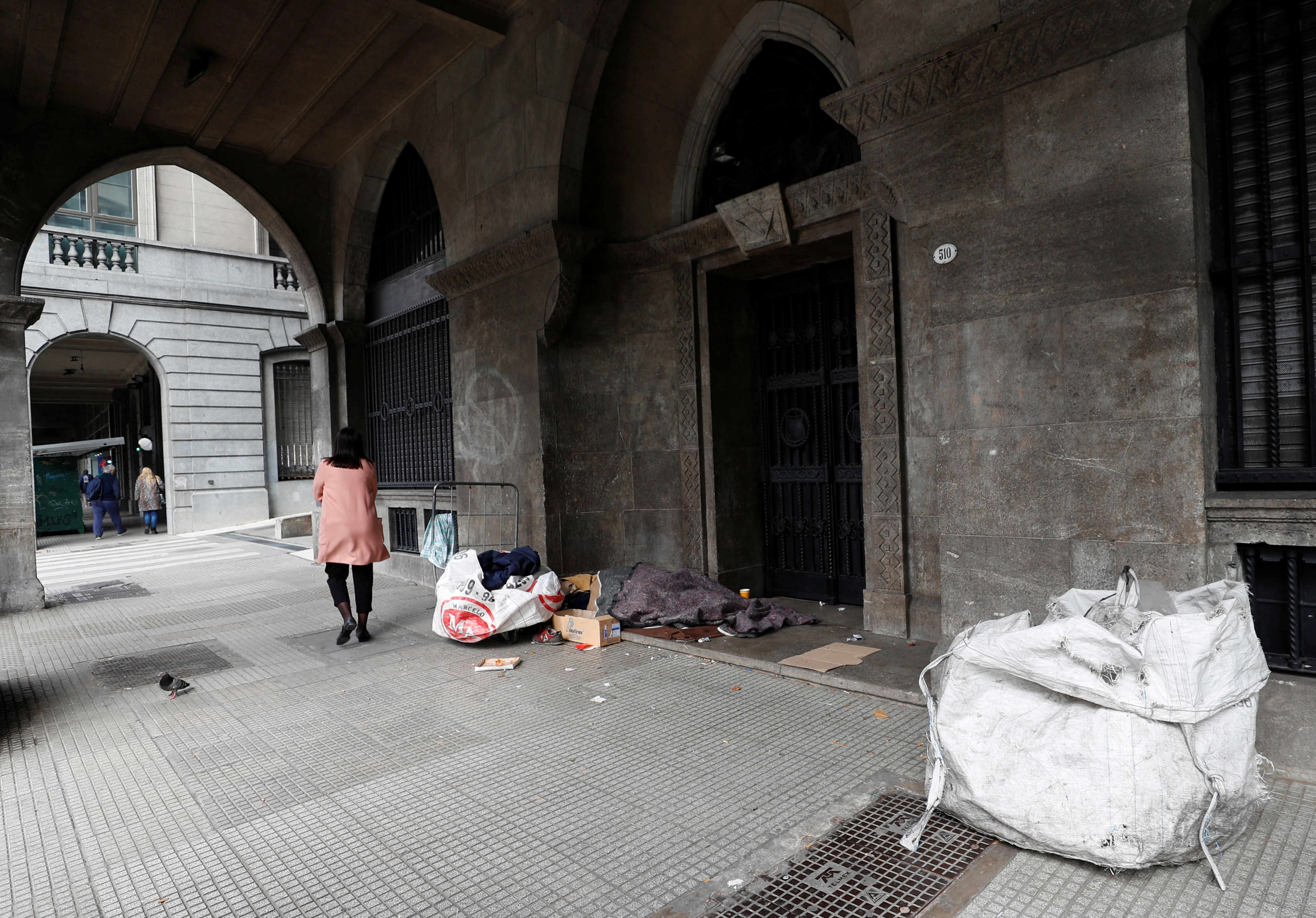 A homeless person sleeps in the street, in downtown Buenos Aires