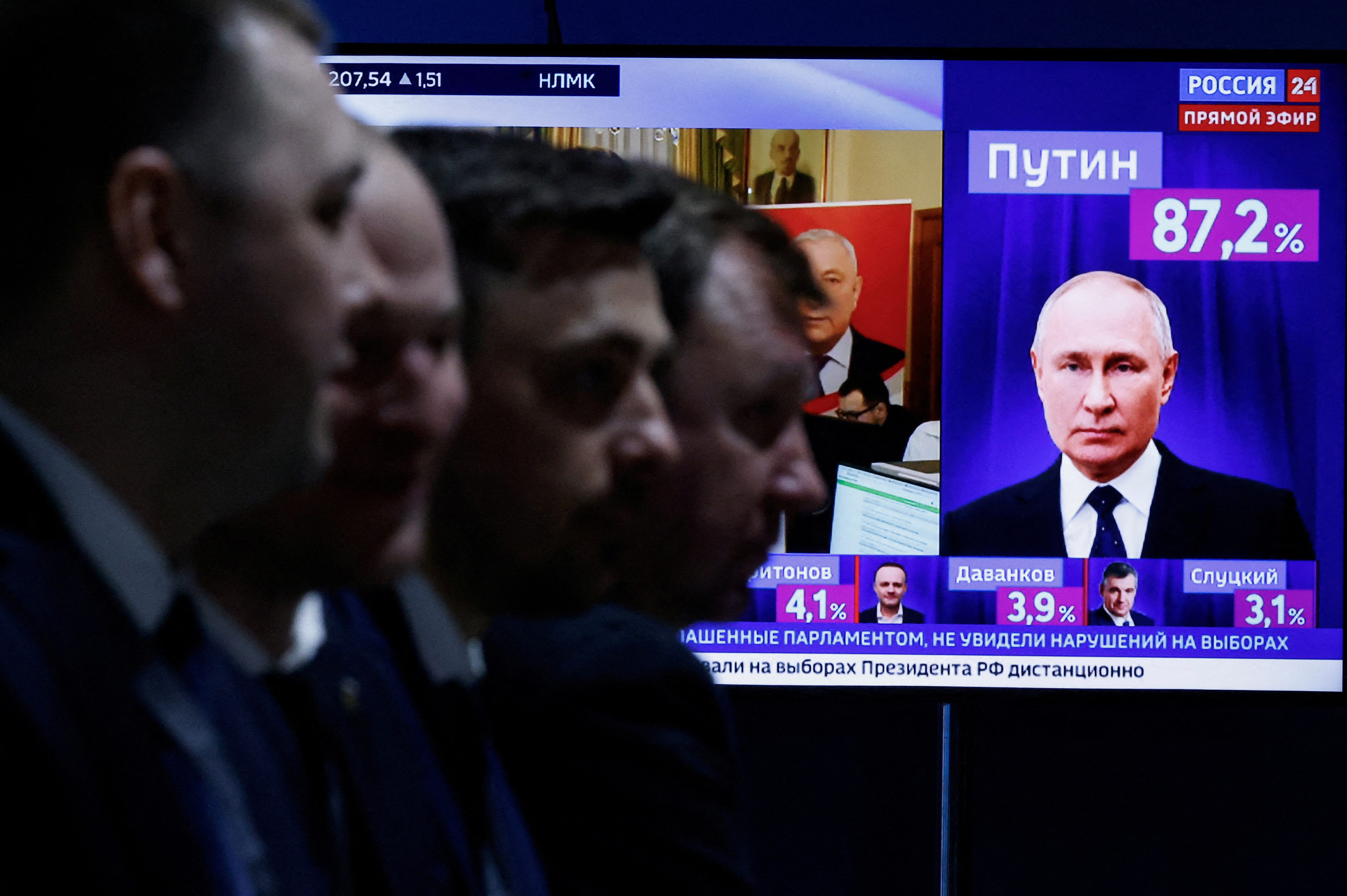 Men sit near a TV on the final day of the presidential election in Moscow, Russia, March 17, 2024. REUTERS/Maxim Shemetov
