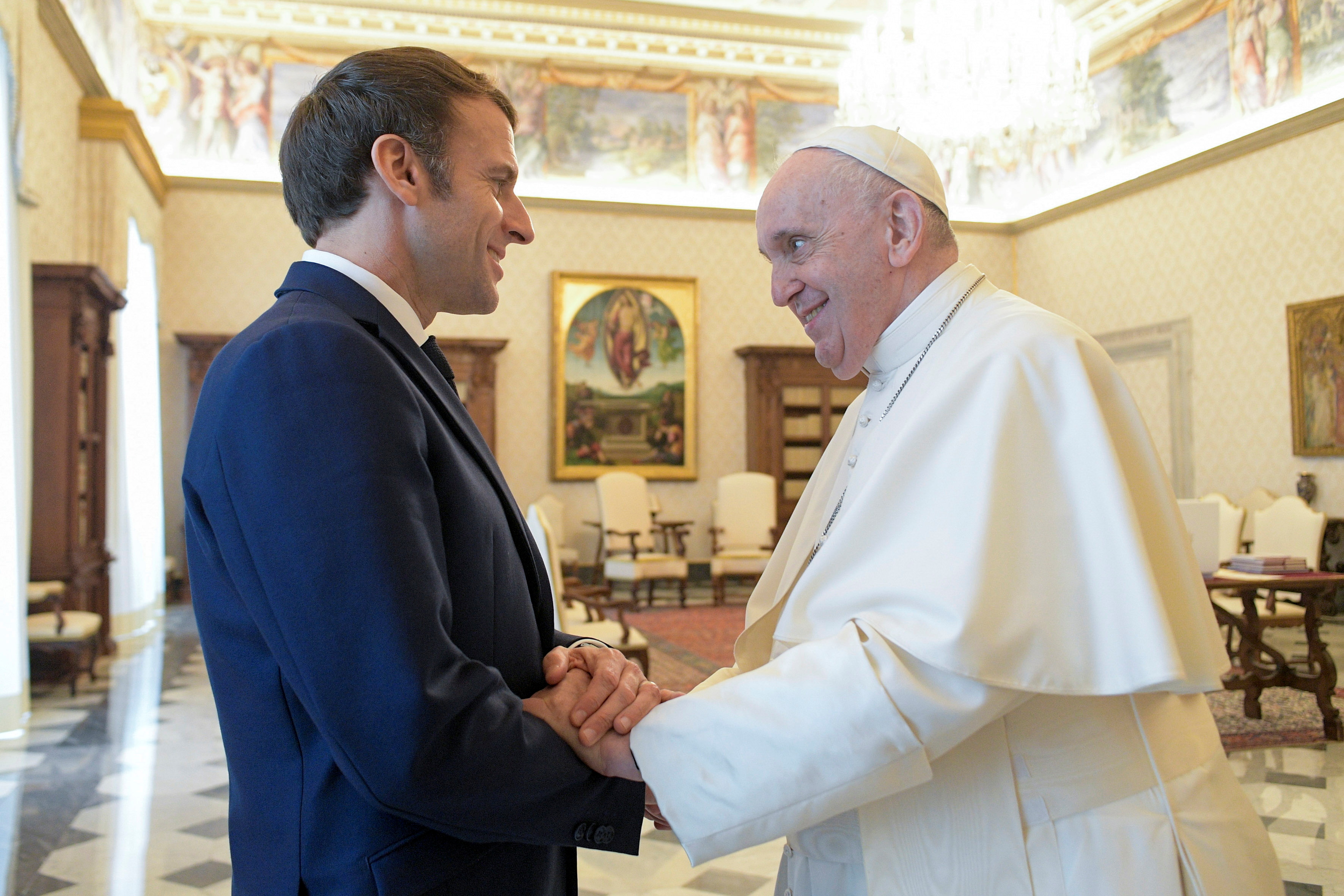 Pope Francis shakes hands with French President Emmanuel Macron during a meeting at the Vatican, November 26, 2021. Vatican Media/Handout via REUTERS   