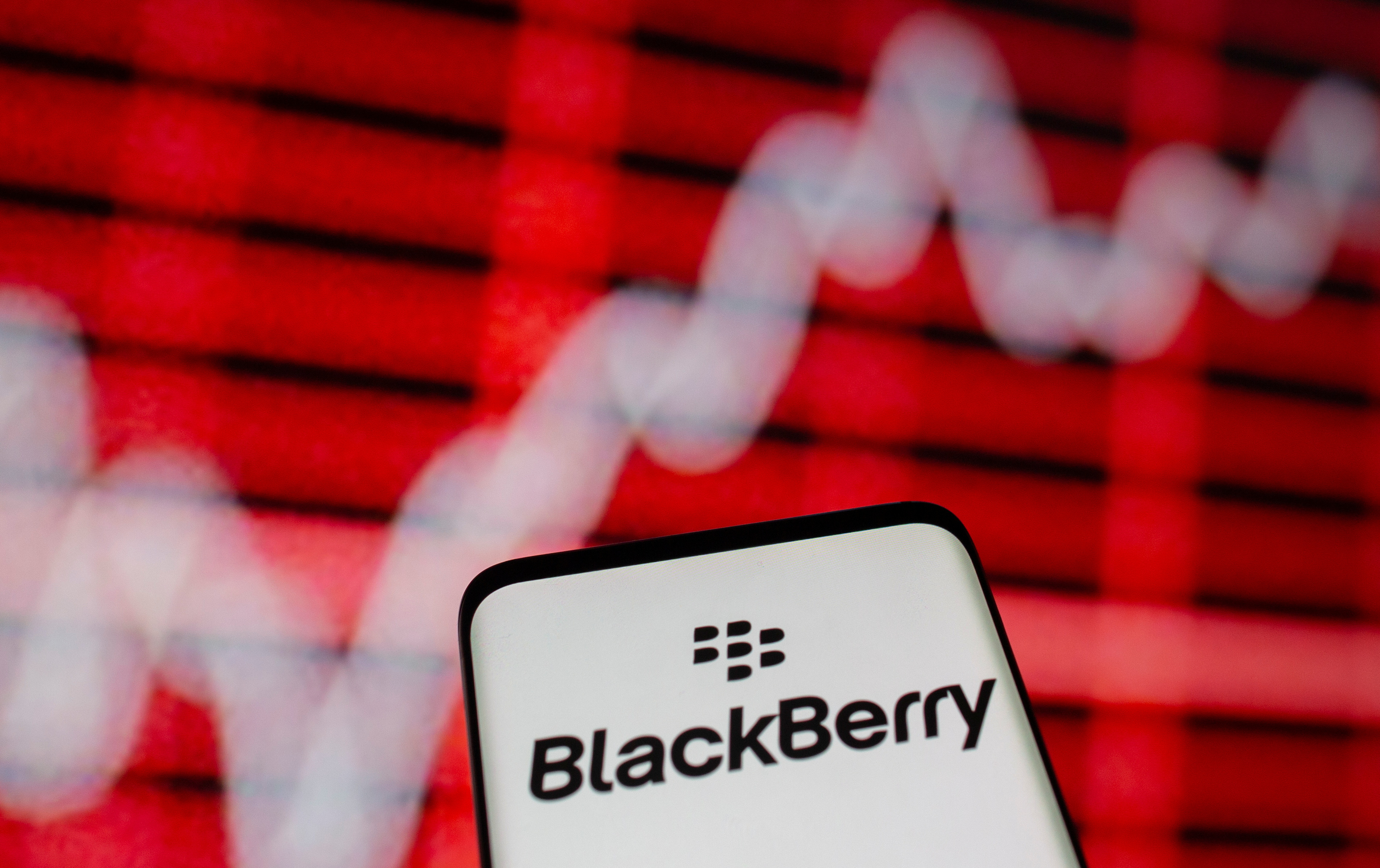 The Blackberry logo is seen on a smarphone in front of a displayed stock graph in this illustration