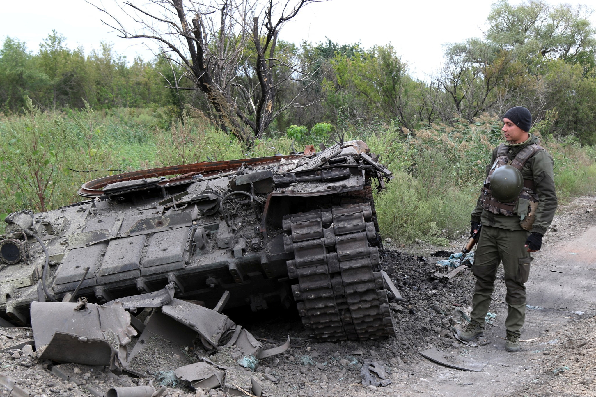 Ukrainian service member inspects a Russian tank destroyed during a counteroffensive operation of the Ukrainian Armed Forces in Kharkiv region