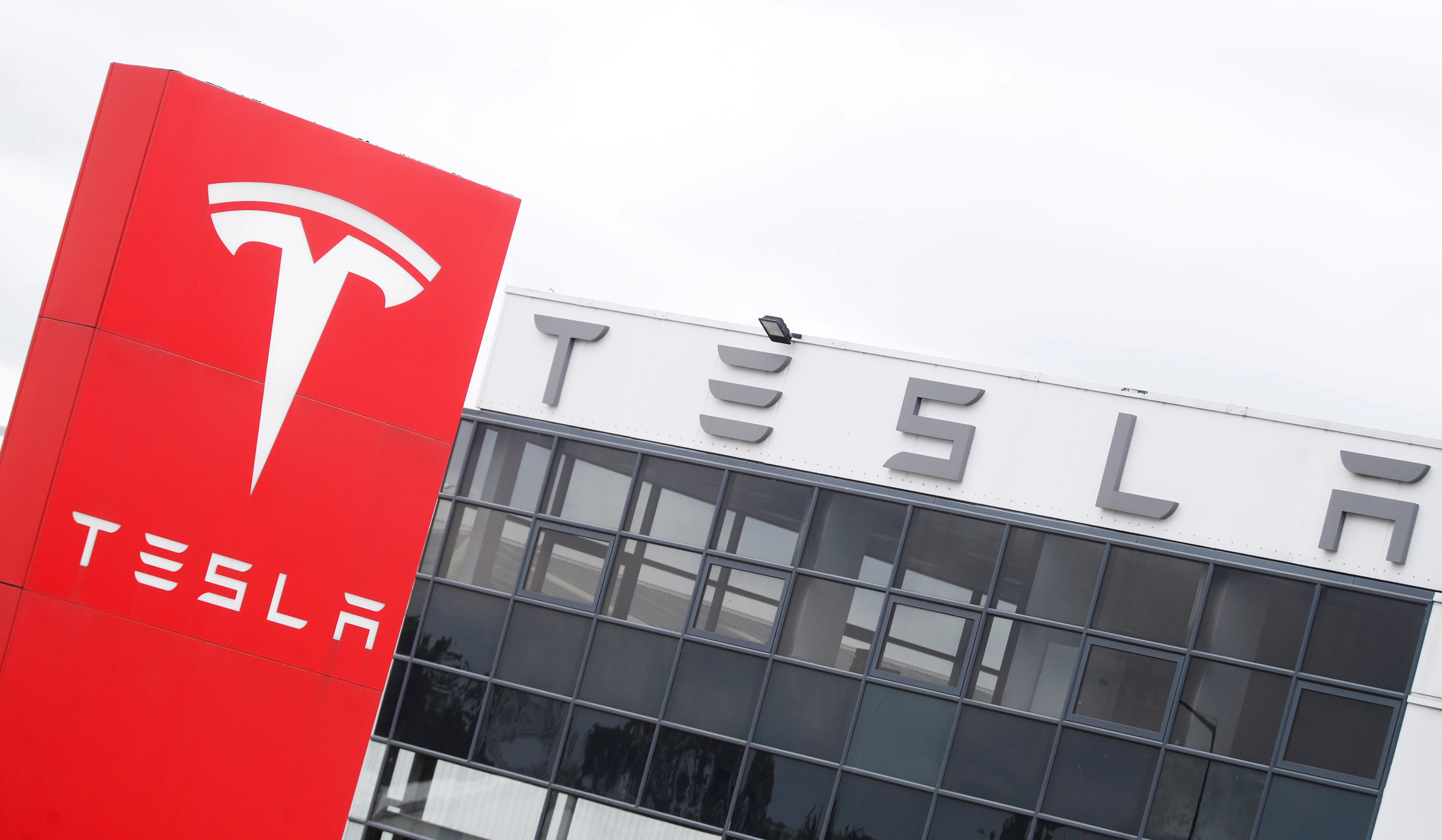 The logo of car manufacturer Tesla is seen at a dealership in London, Britain, May 14, 2021. REUTERS/Matthew Childs/File Photo