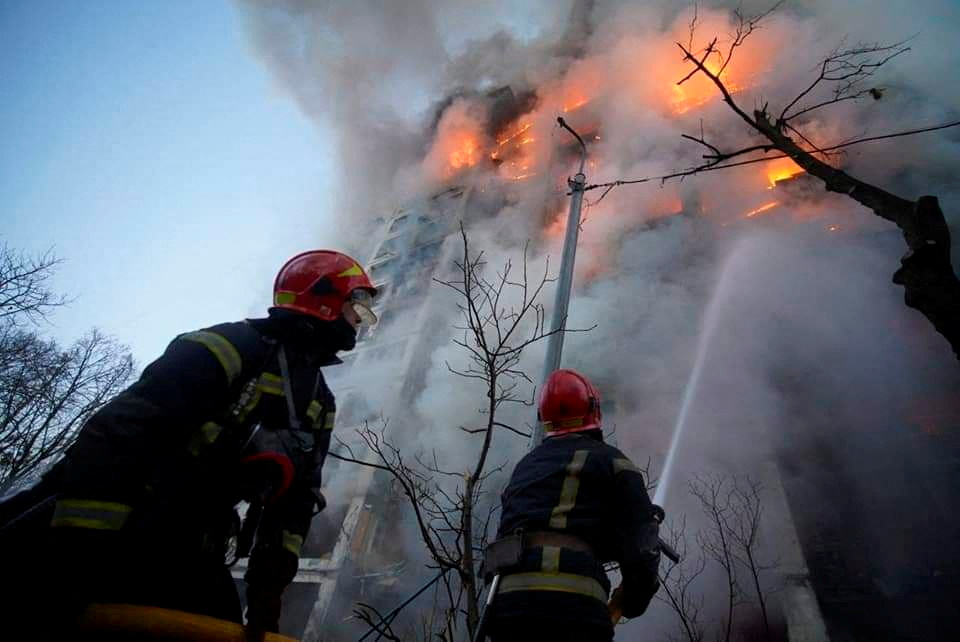 Rescuers work next to a residential building damaged by shelling in Kyiv