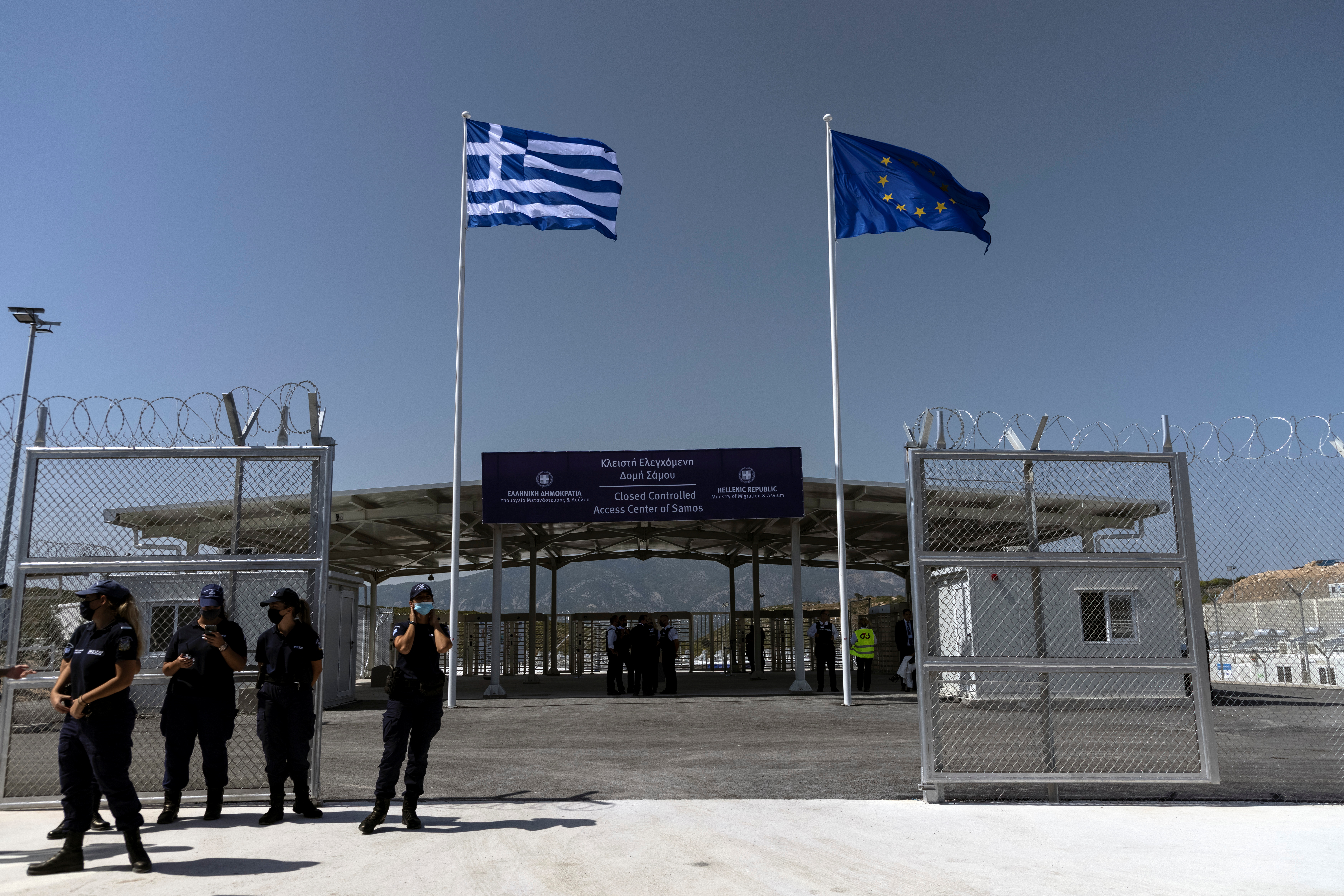 A Greek national flag and a European Union flag flutter inside a newly inaugurated closed-type migrant camp on the island of Samos, Greece, September 18, 2021.  REUTERS/Alkis Konstantinidis