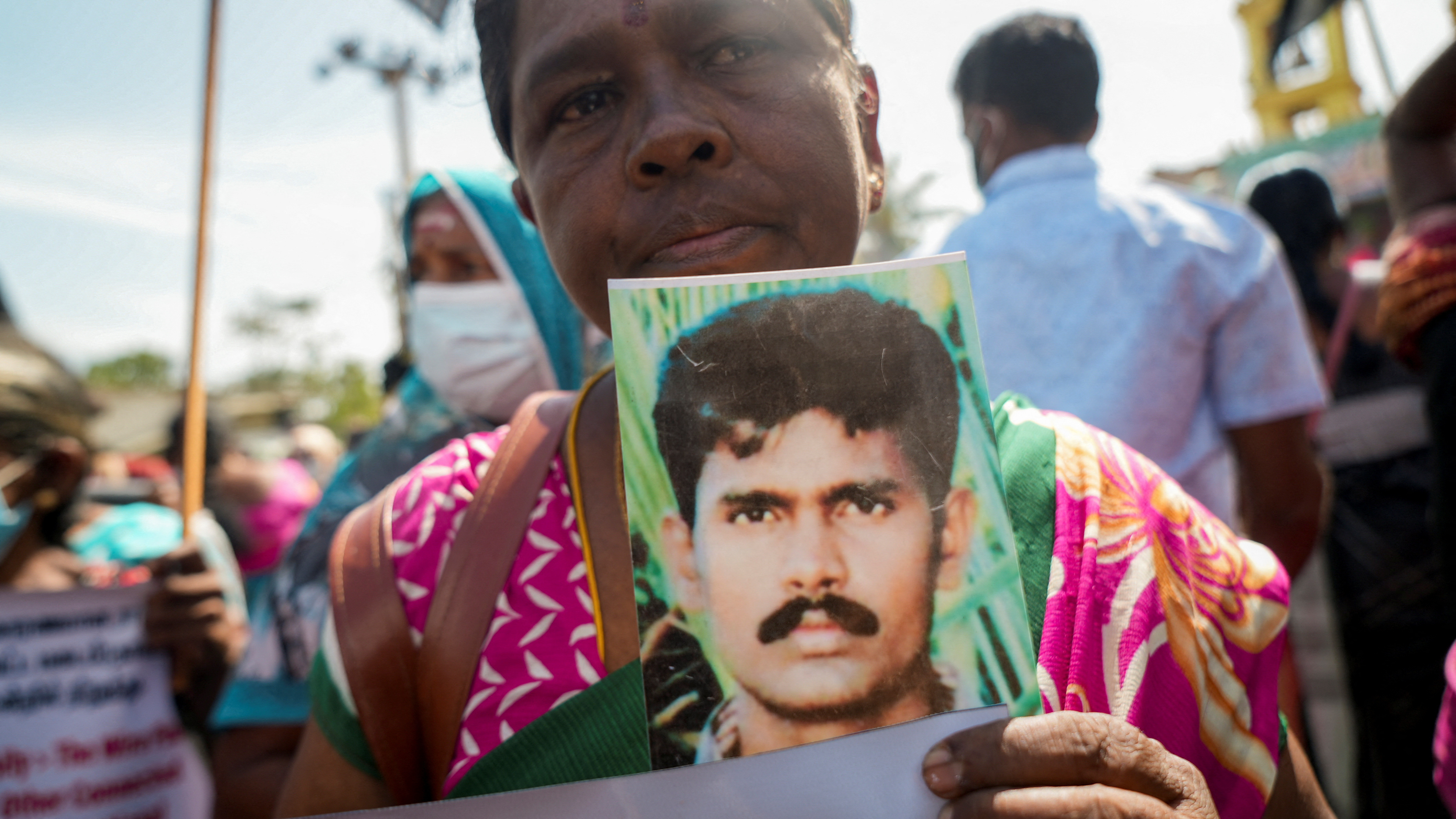 A woman holds up a photo of her missing relative during a protest in Kilinochchi