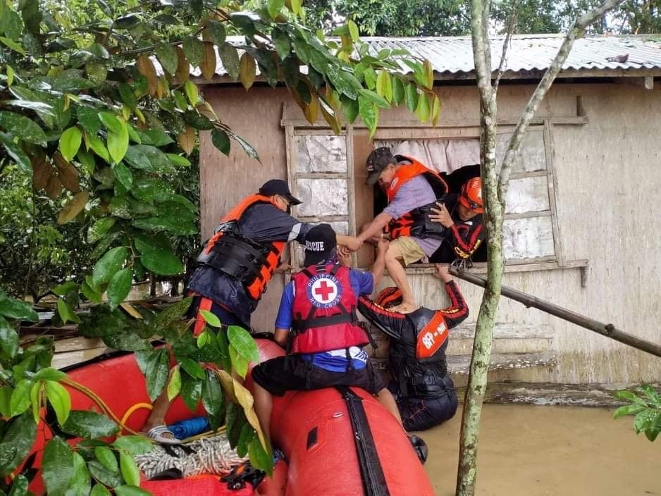 Rescue personnel assist a man onto a rescue boat, after the tropical storm Megi hit, in Capiz Province