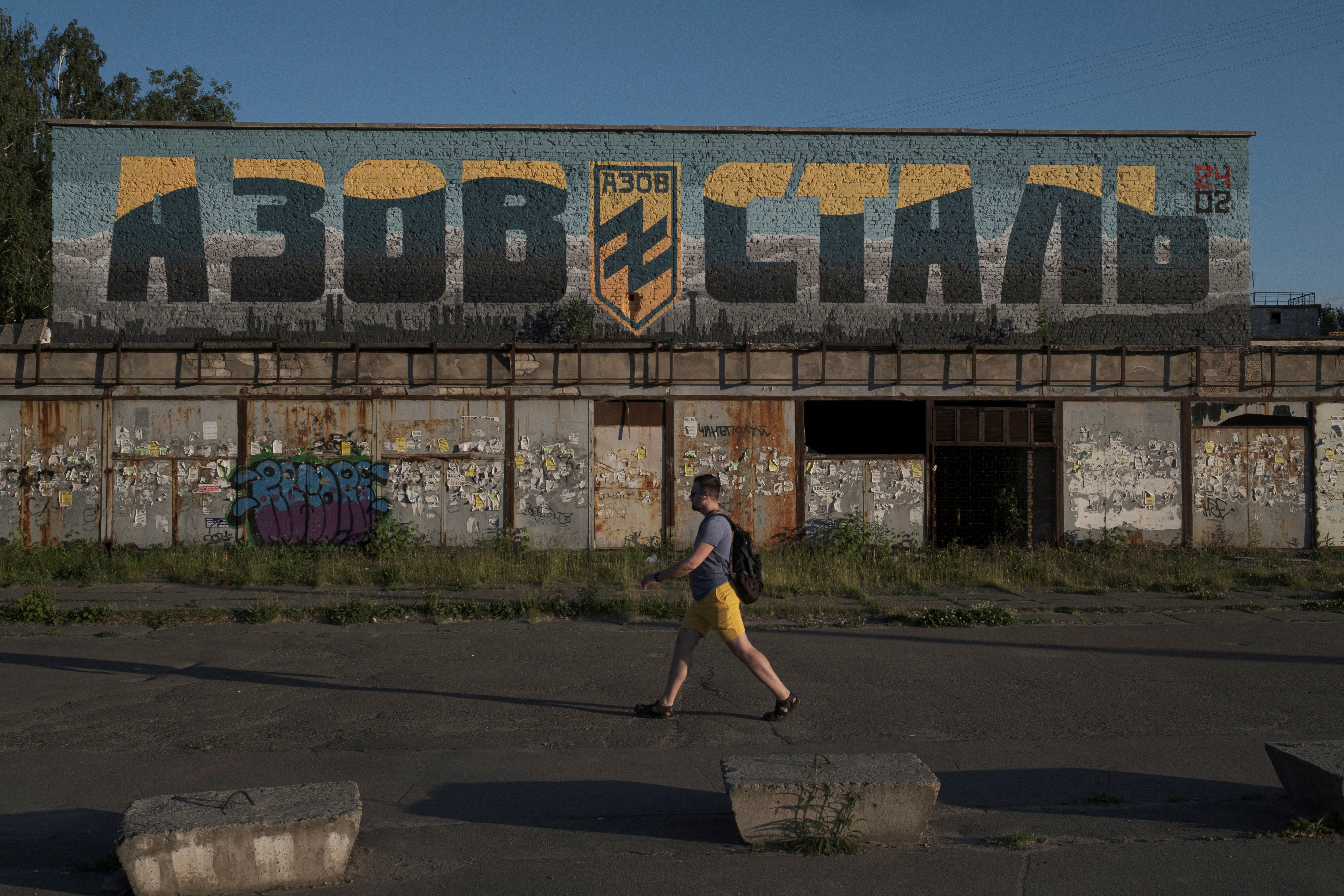 A man walks past a mural painted in honour of the Azov Regiment in Kyiv