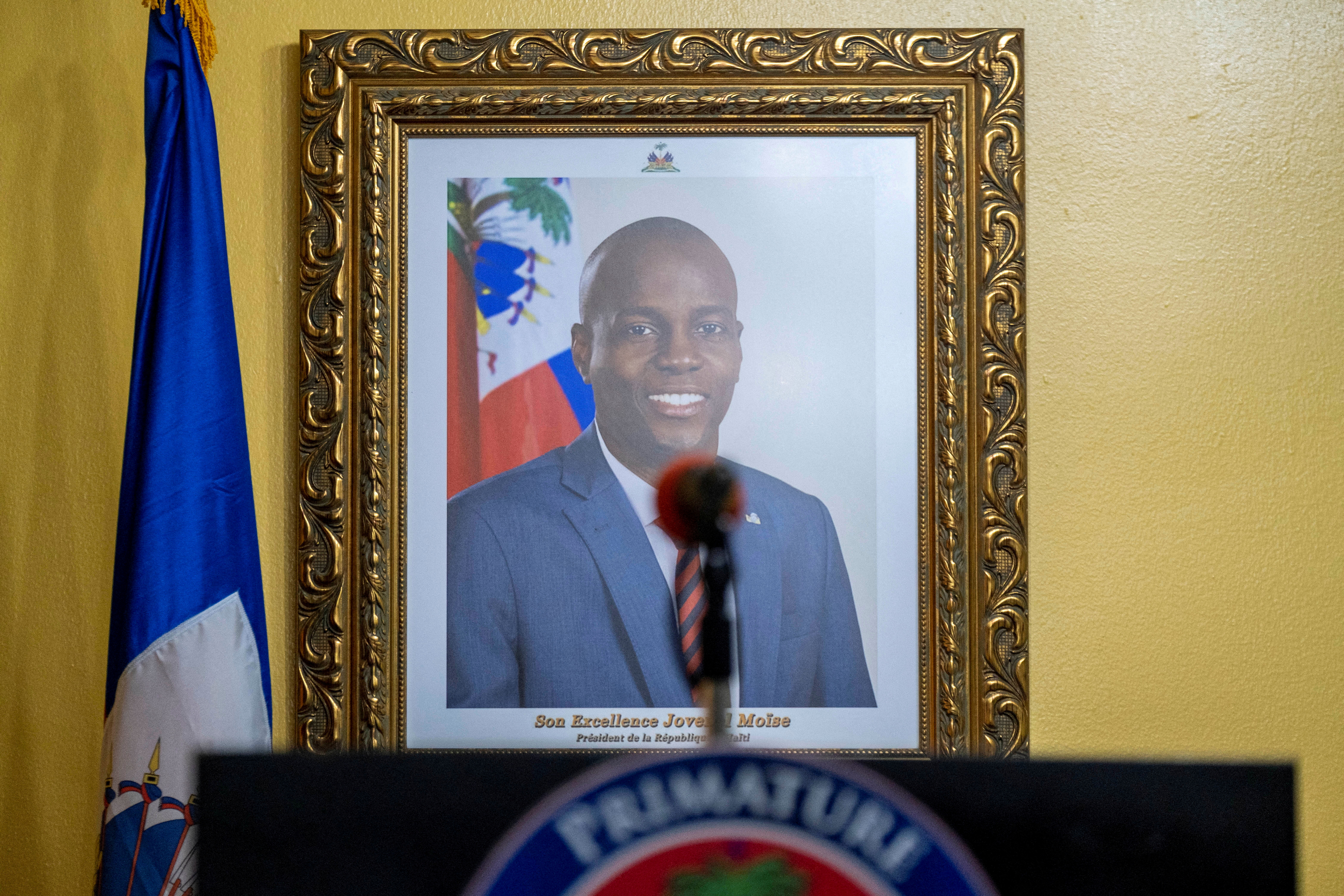 A picture of the late Haitian President Jovenel Moise hangs on a wall before a news conference
