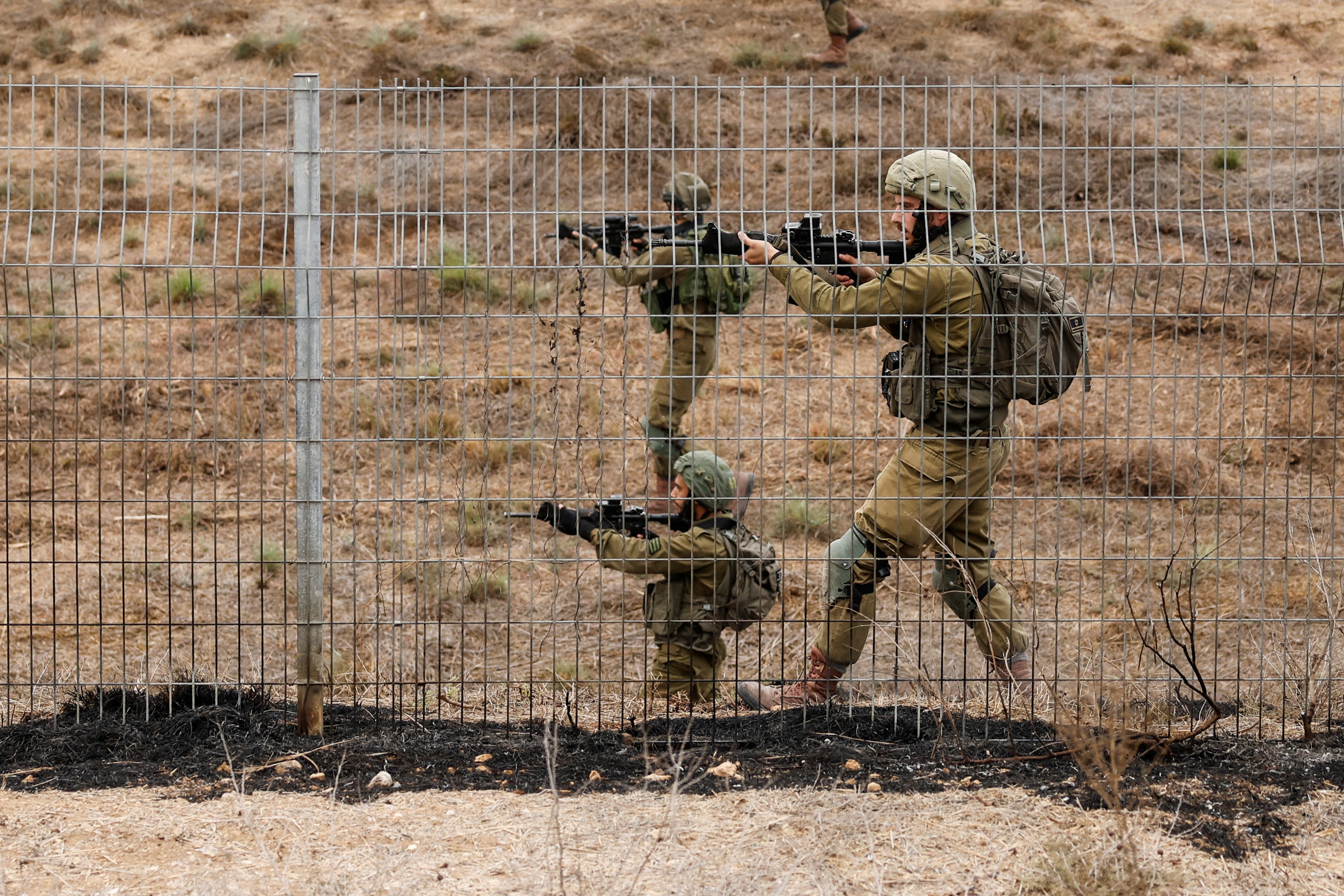 Israeli soldiers scan an area while sirens sound as rockets from Gaza are launched towards Israel,, near Sderot, southern Israel