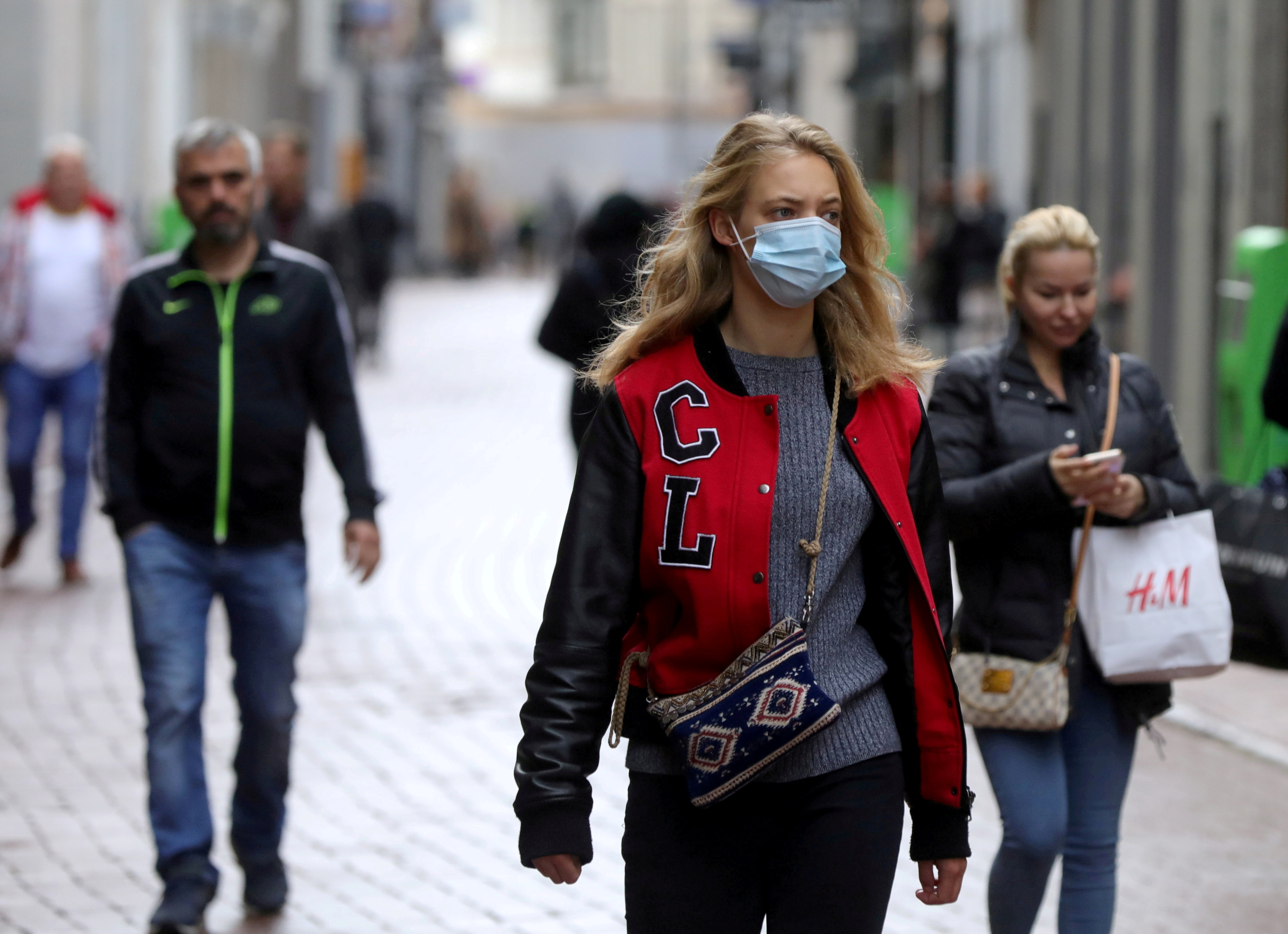 People with and without protective masks walk on the street while shopping as the spread of coronavirus disease (COVID-19) continues in Amsterdam, Netherlands October 7, 2020. REUTERS/Eva Plevier