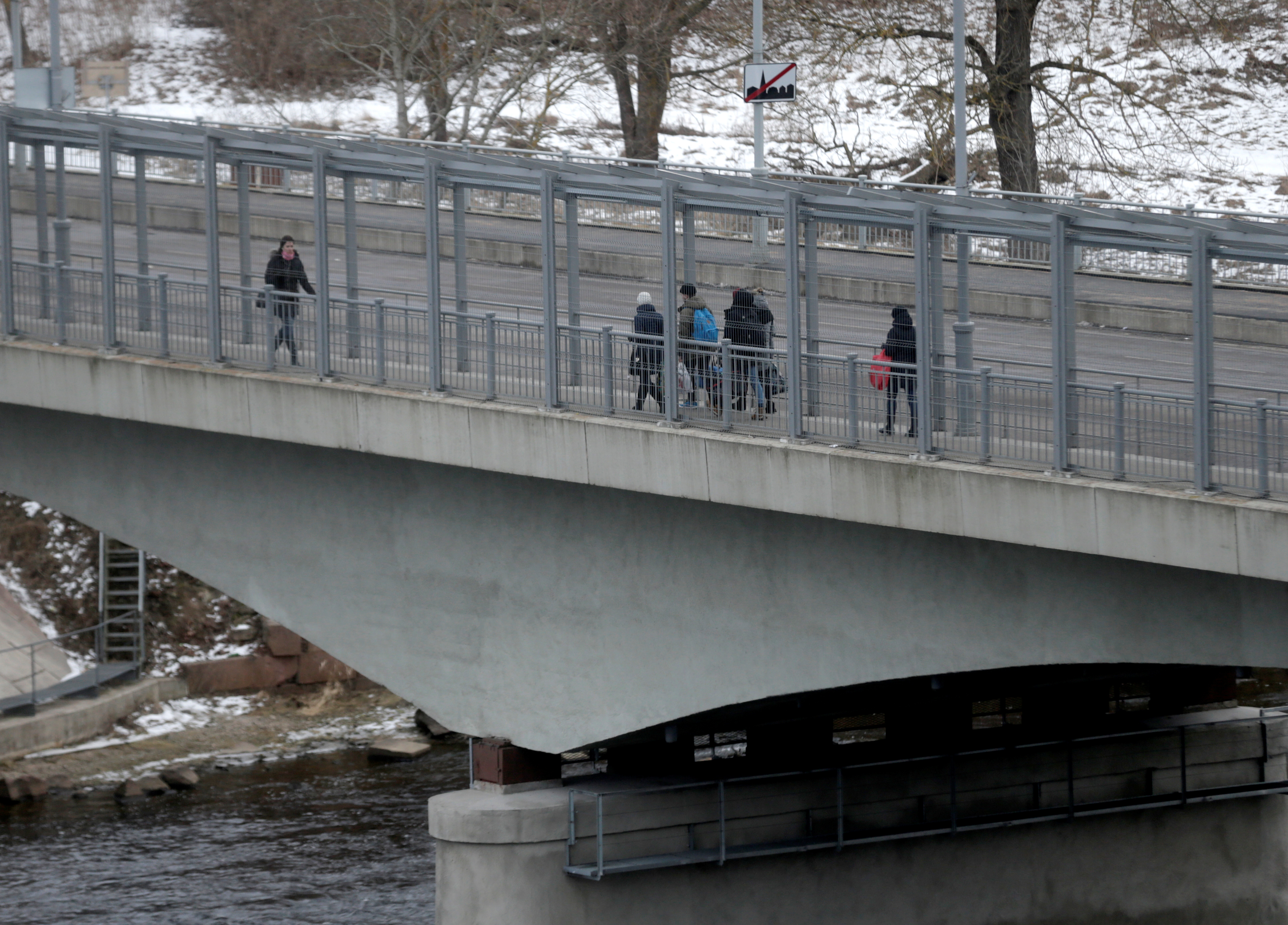 People walk on the bridge over Narva river at the border crossing point with Russia in Narva, Estonia February 16, 2017. Picture taken February 16, 2017. REUTERS/Ints Kalnins