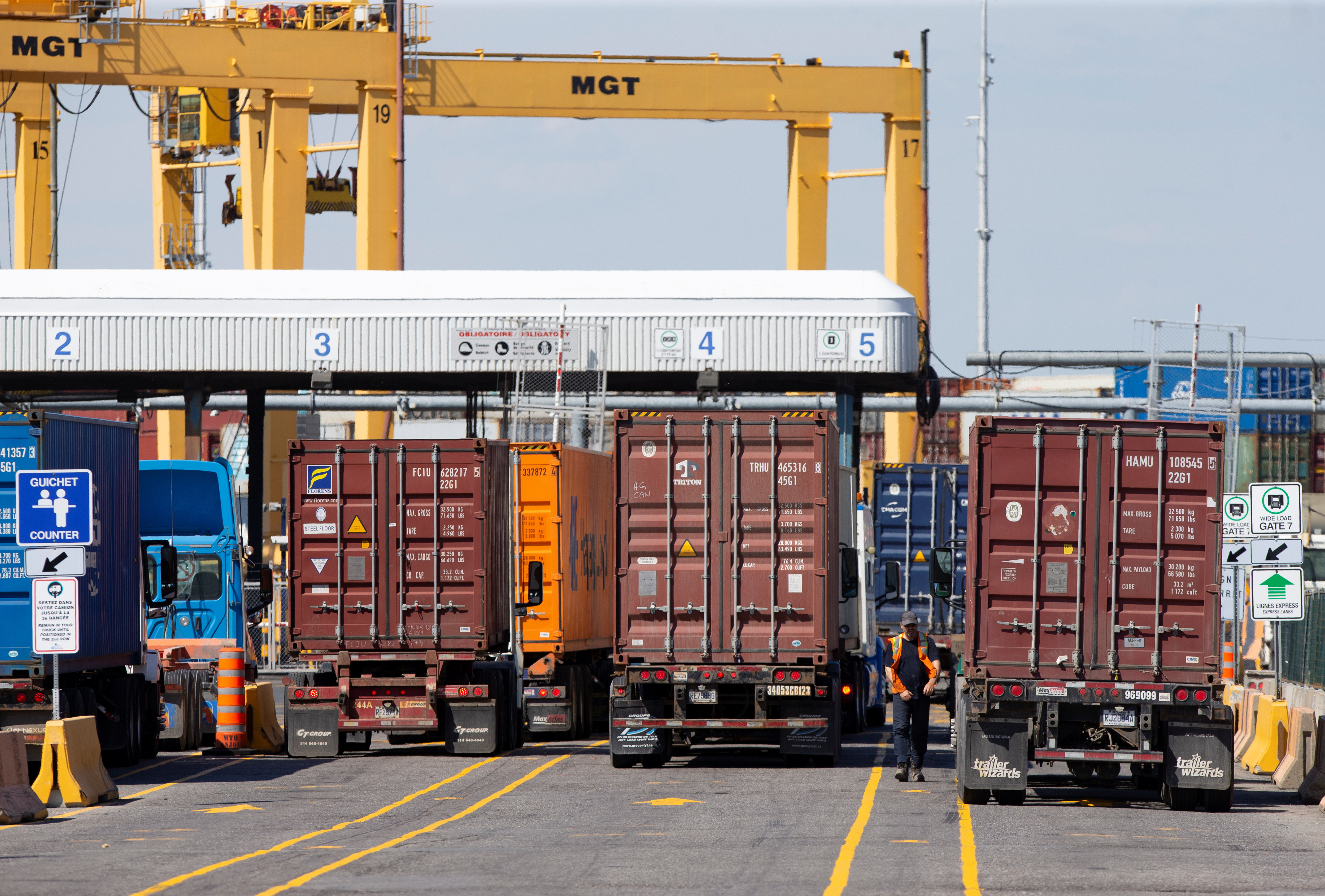 Trucks loaded with shipping containers arrive at the Port of Montreal