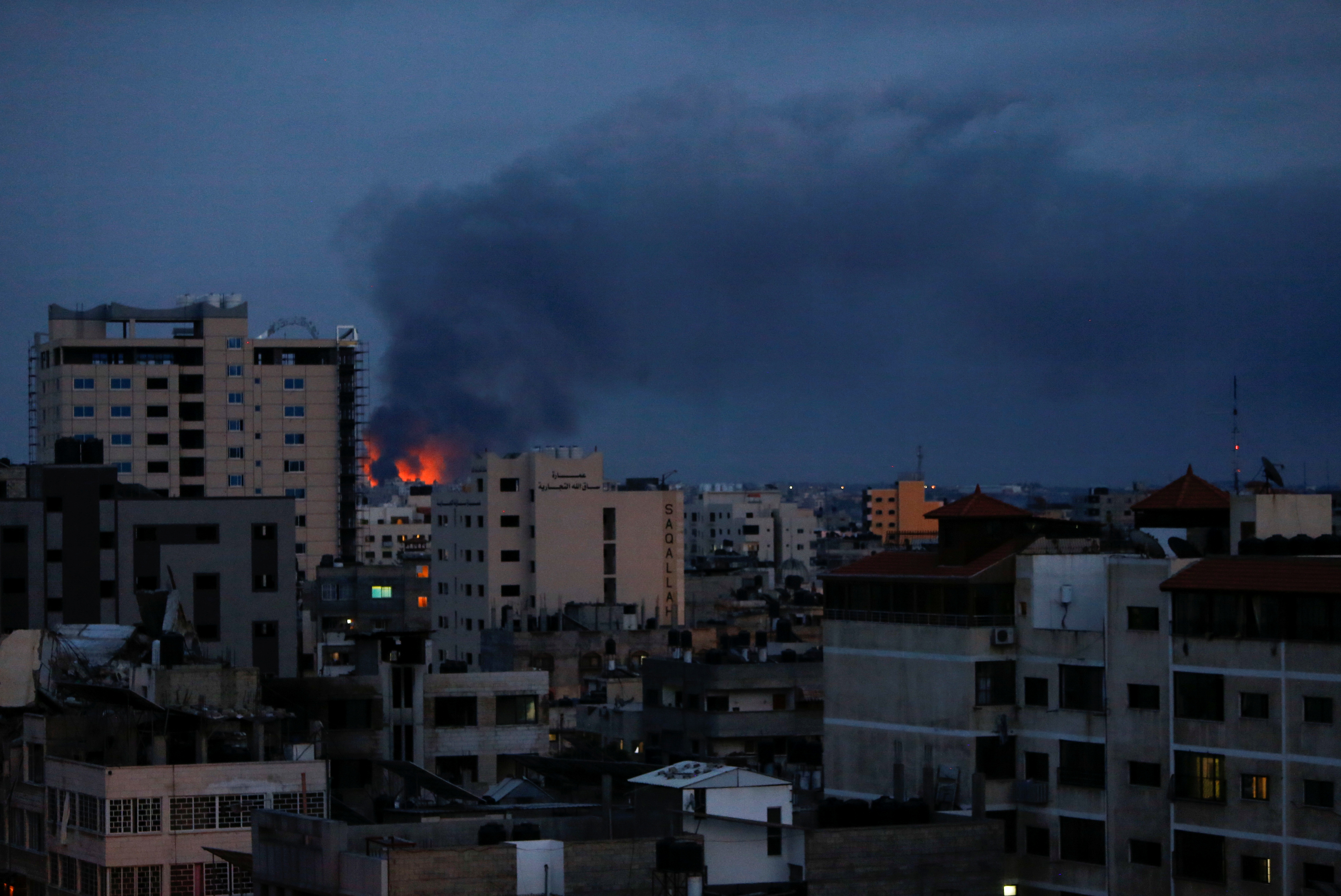 Smoke and flames are seen above buildings in Gaza
