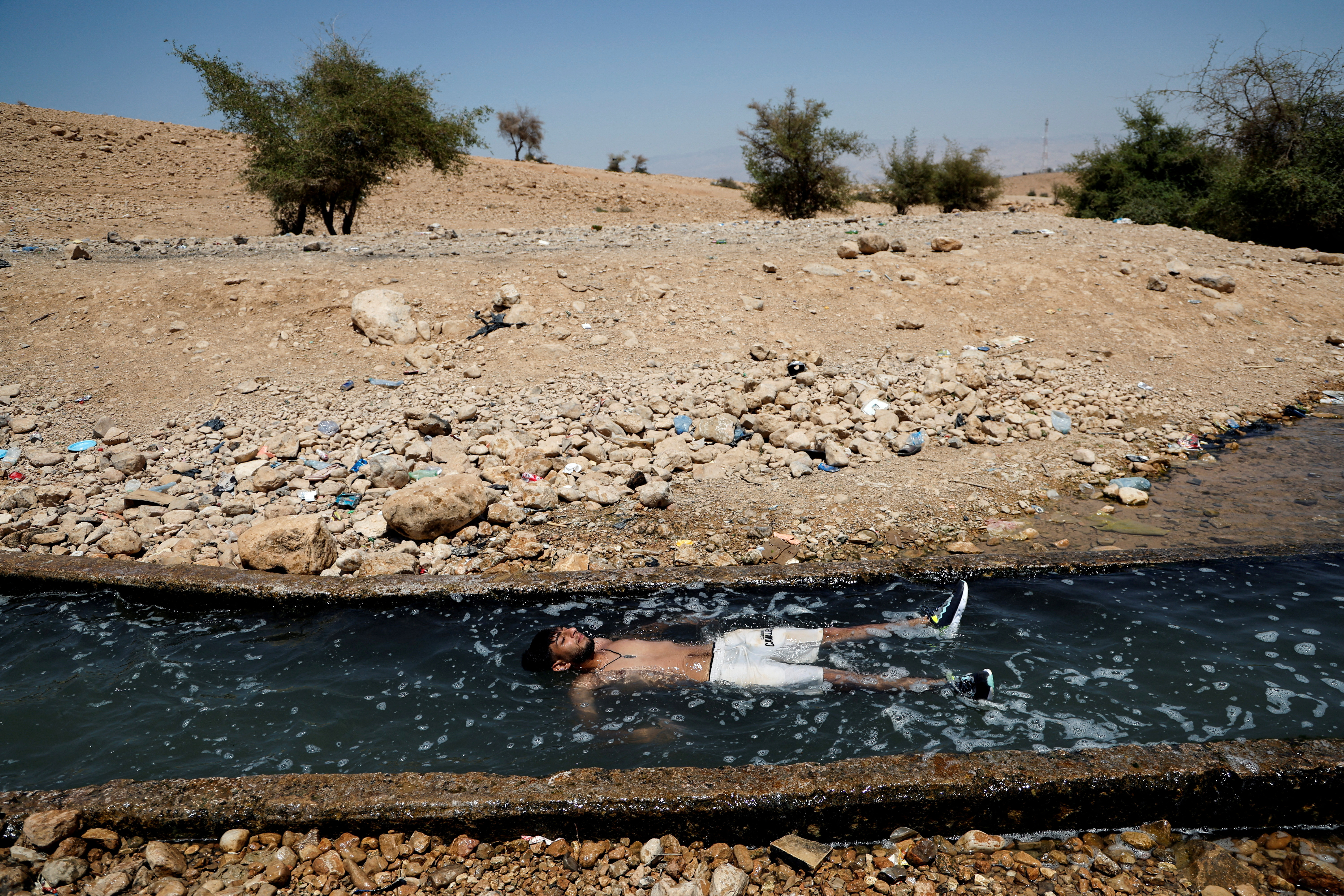 A Palestinian man cools off during a heat wave, in al-Oja springs near Jericho in the Israeli-occupied West Bank
