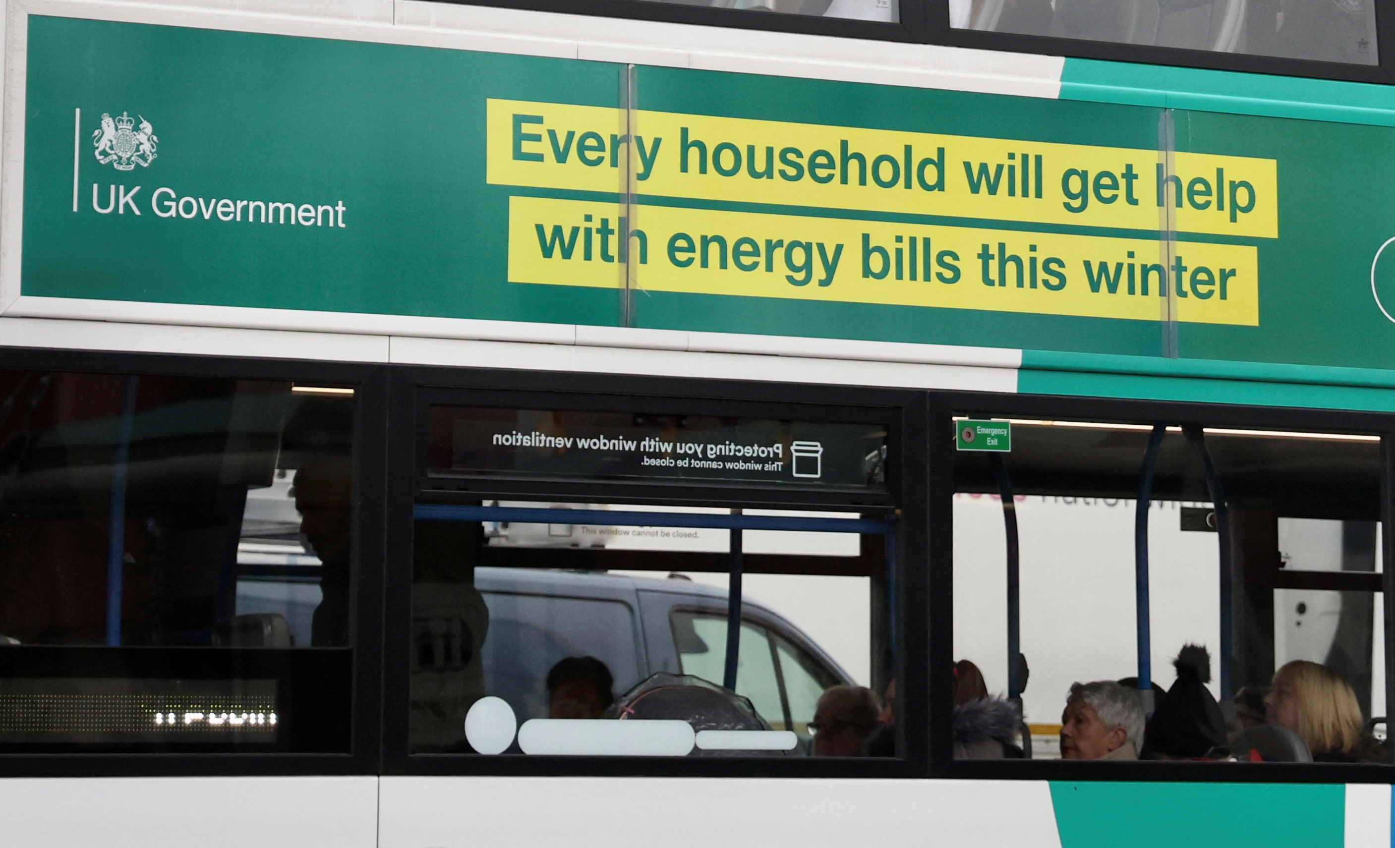 Op de zijkant van een bus in Stockport is een advertentie van de Britse regering te zien waarin mensen worden geholpen met de energierekening in de winter