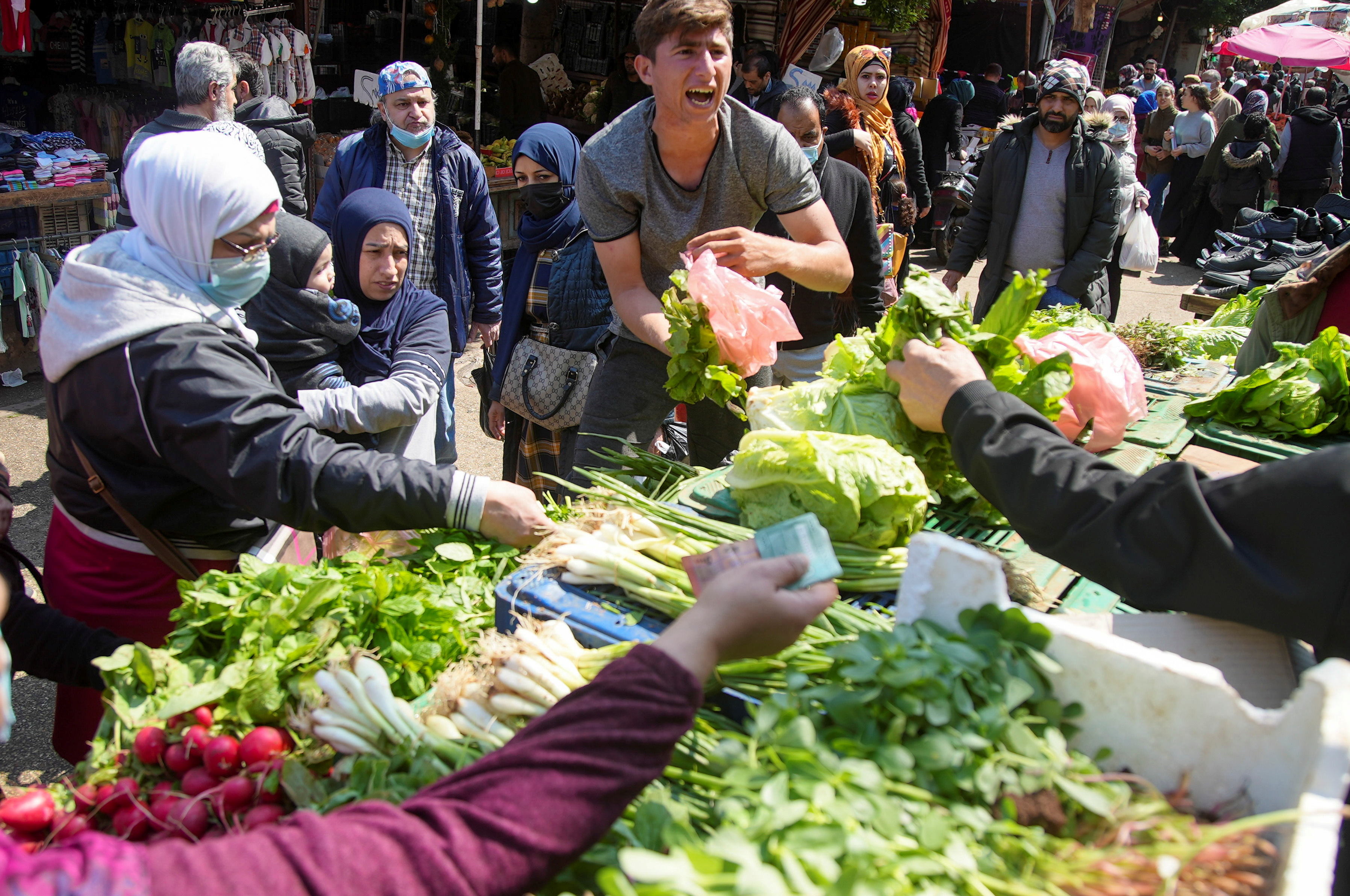 People shop for vegetables at a souk in Beirut