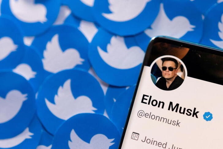 Illustration shows Elon Musk's Twitter profile on smartphone and printed Twitter logos