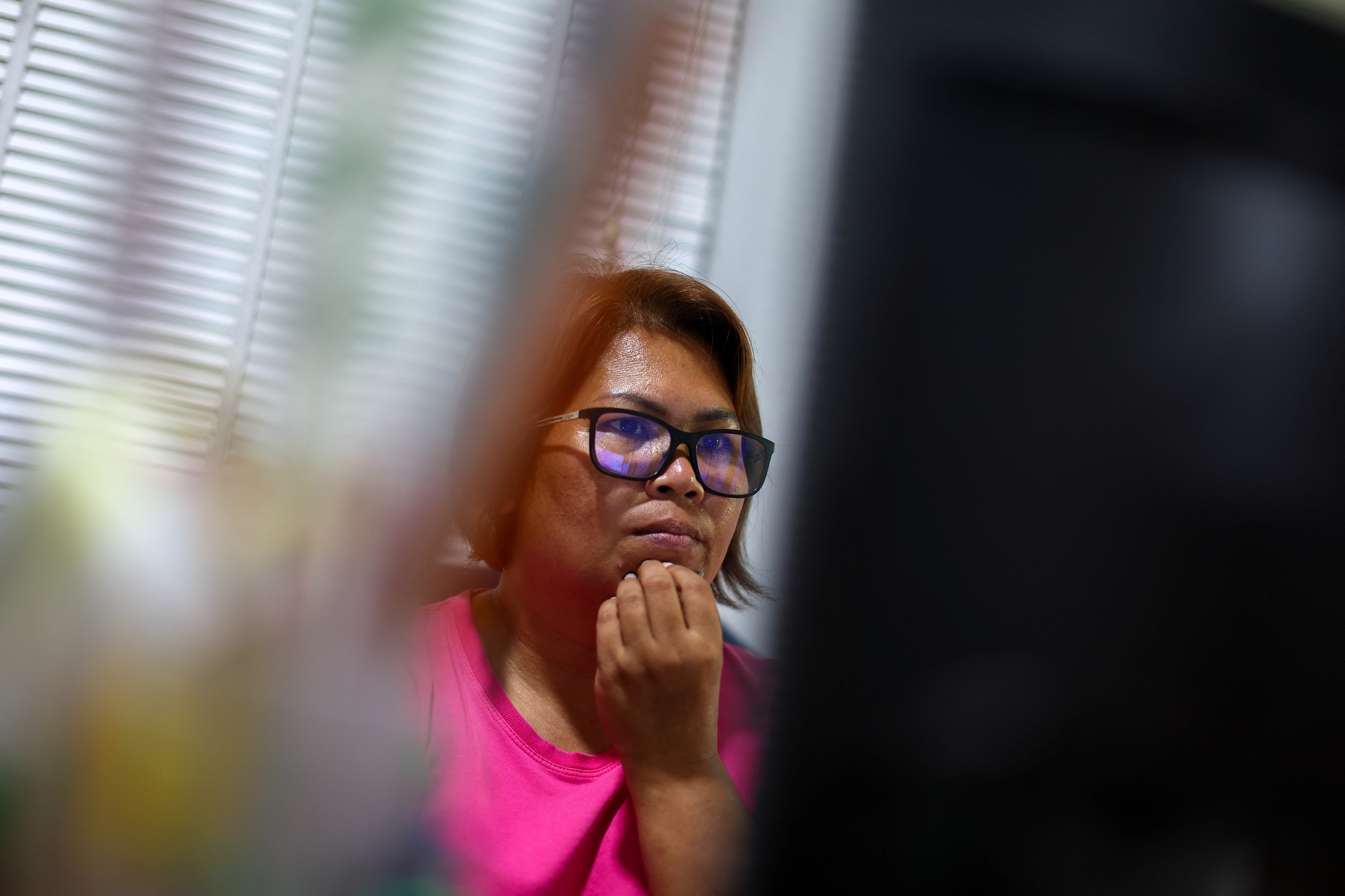 Kavita Wongyakasem, a small business owner, reacts as she finds out that her bank account is insufficient to pay her bills at her house in Nonthaburi province on the outskirt of Bangkok