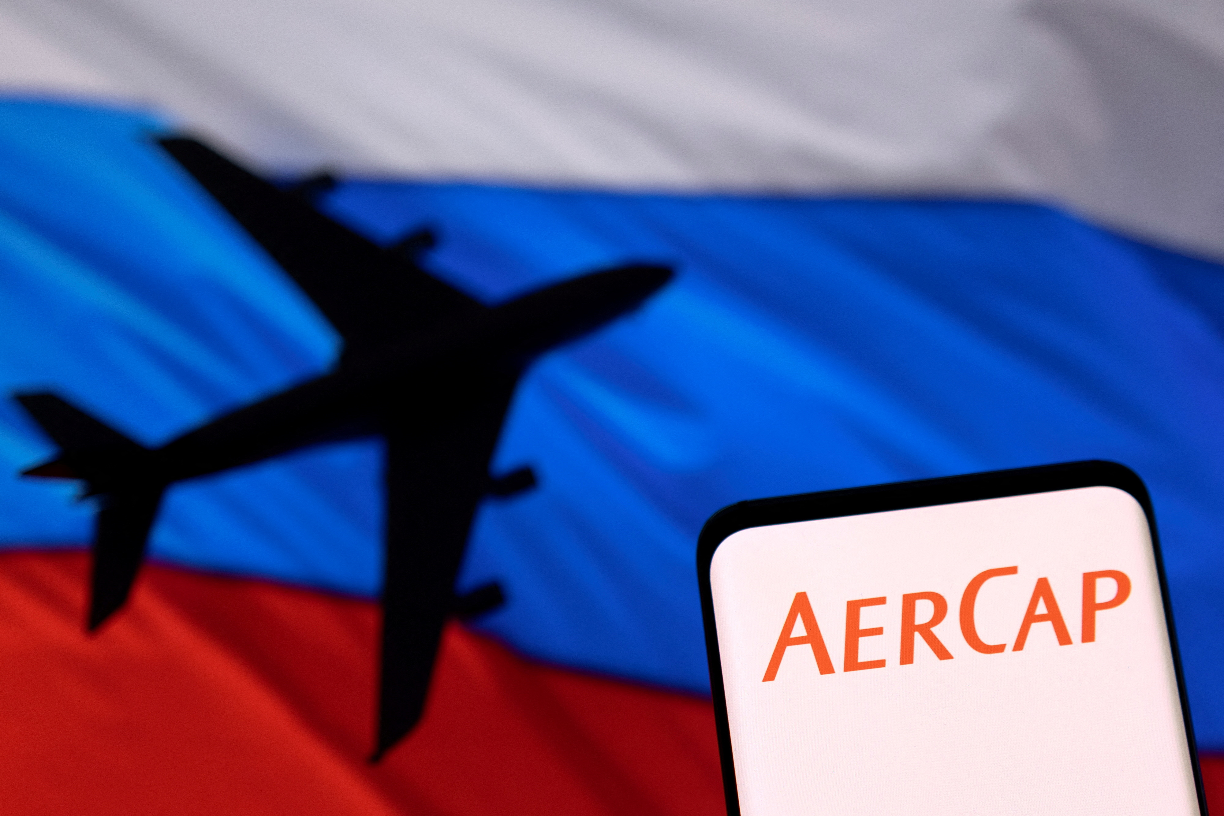 Illustration shows AerCap logo displayed in front of the model of an airplane and a Russian flag