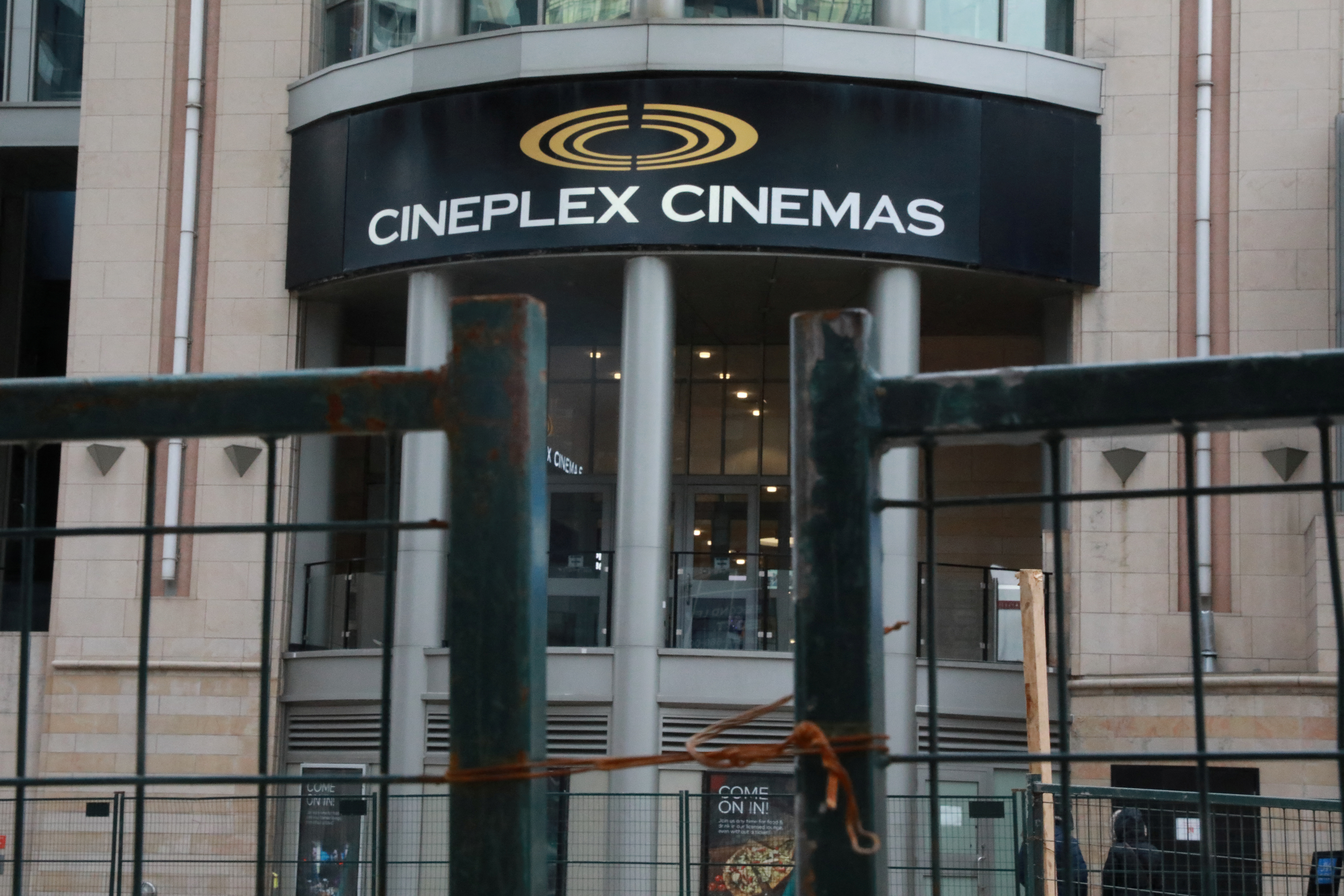 A Cineplex movie theatre sign is seen over a construction gate on Yonge street in Toronto