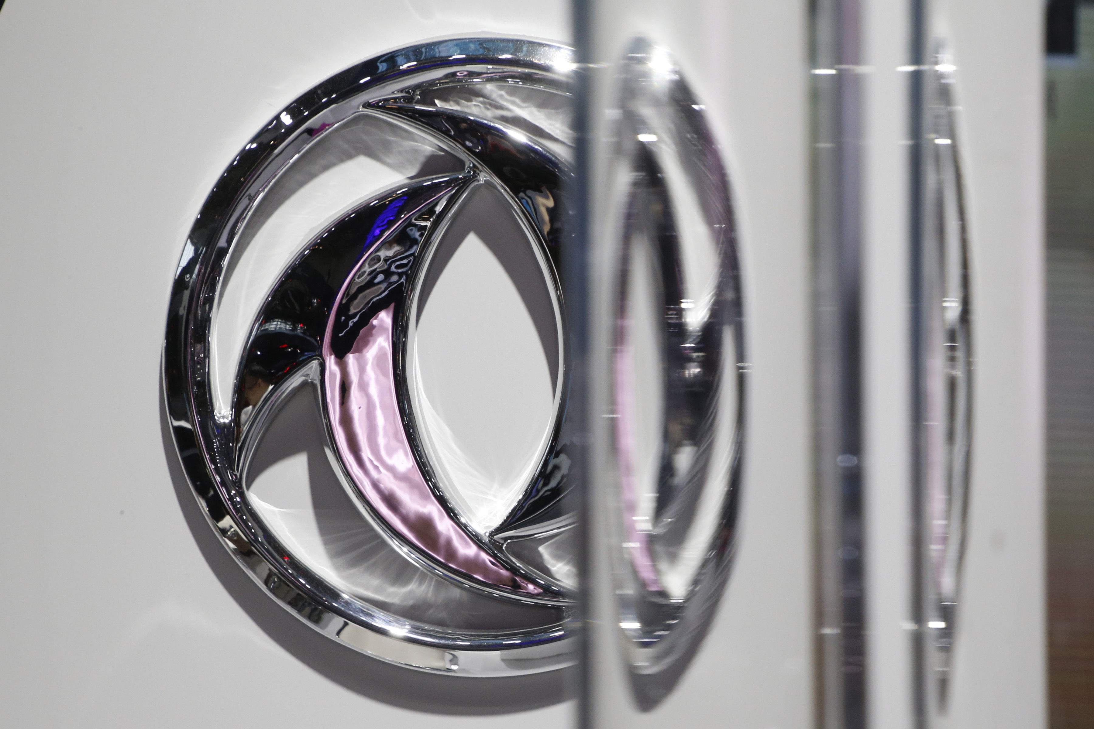 The logo of Dongfeng Motor Corp is seen behind glass door at the Auto China 2016 auto show in Beijing